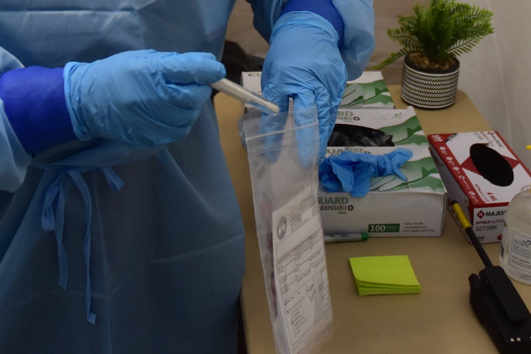 Emergency worker Melanie Chavez takes a COVID-19 test sample at the Juneau International Airport screening site on Monday, Oct. 12, 2020. (Peter Segall / Juneau Empire)