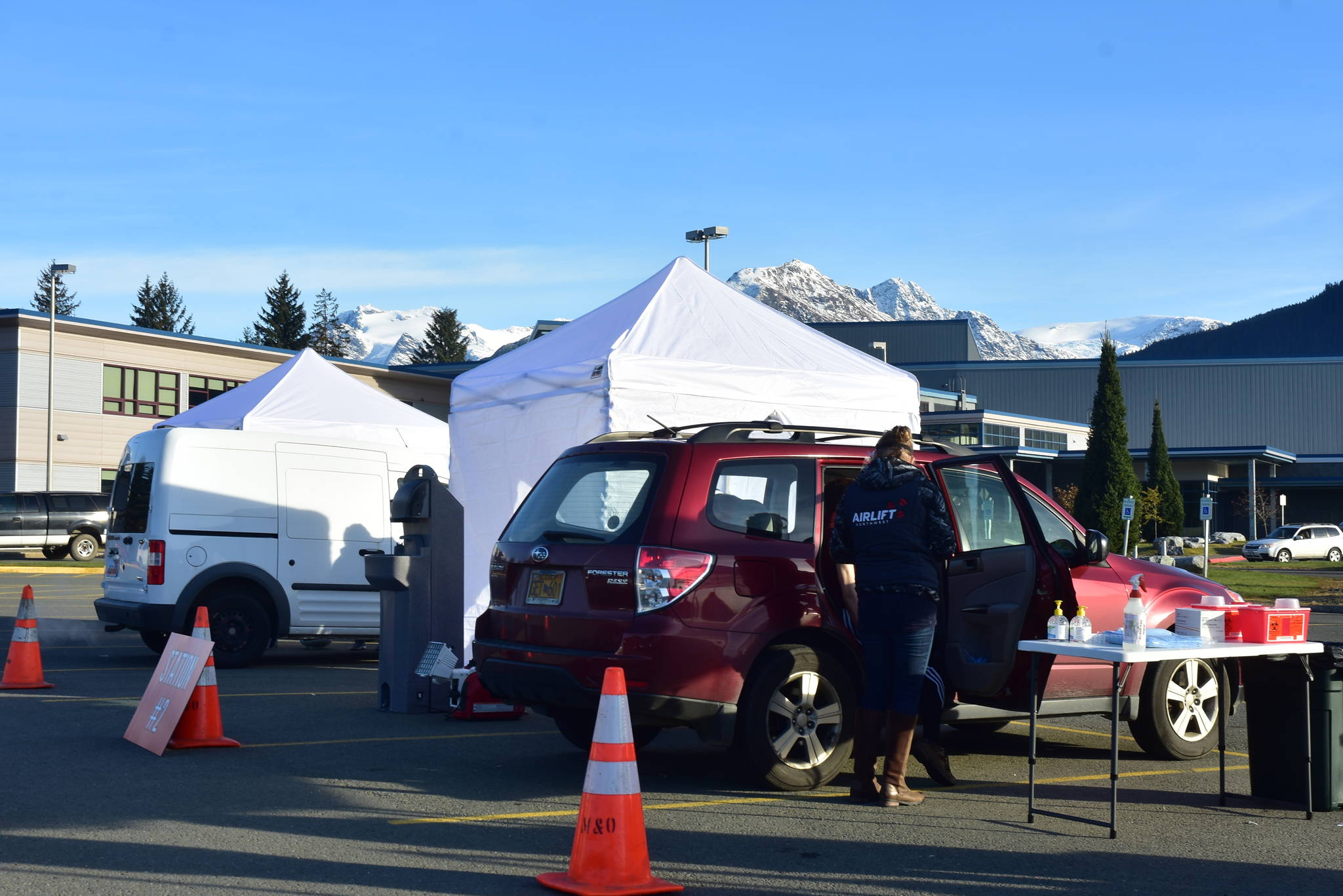 Health care workers help distribute flu vaccines to thousands of Juneau residents at Thunder Mountain High School on Saturday, Oct. 24, 2020. Local health authorities said the drive-thru clinic was a practice run for an eventual mass distribution of a COVID-19 vaccine. (Peter Segall / Juneau Empire)