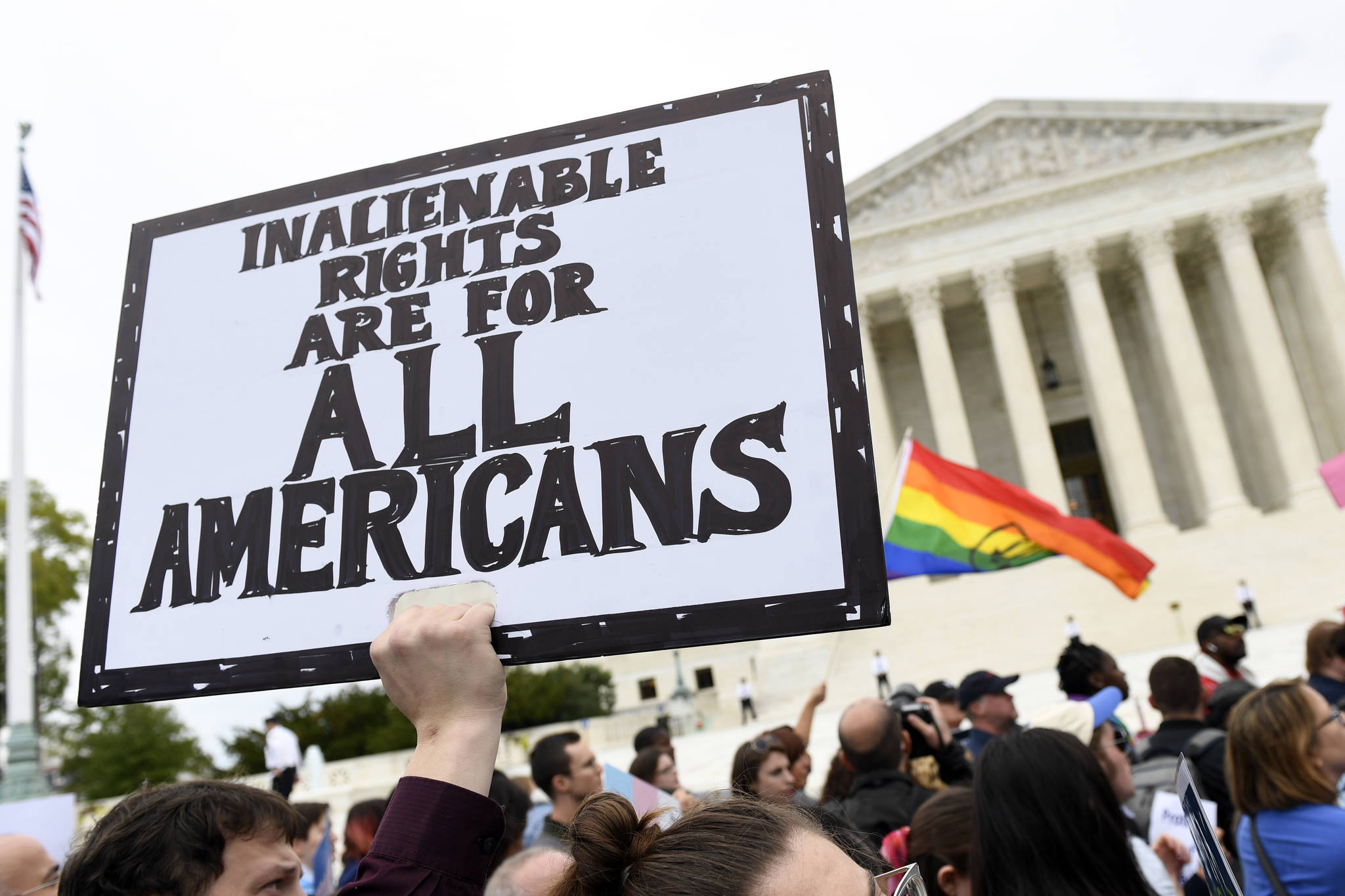 In this Oct. 8, 2019, file photo, protesters gather outside the Supreme Court in Washington where the Supreme Court is hearing arguments in the first case of LGBT rights since the retirement of Supreme Court Justice Anthony Kennedy.  As vice president in 2012, Joe Biden endeared himself to many LGBTQ Americans by endorsing same-sex marriage even before his boss, President Barack Obama. Now, as president-elect, Biden is making sweeping promises to LGBTQ activists, proposing to carry out virtually every major proposal on their wish lists.   (AP Photo / Susan Walsh, File)