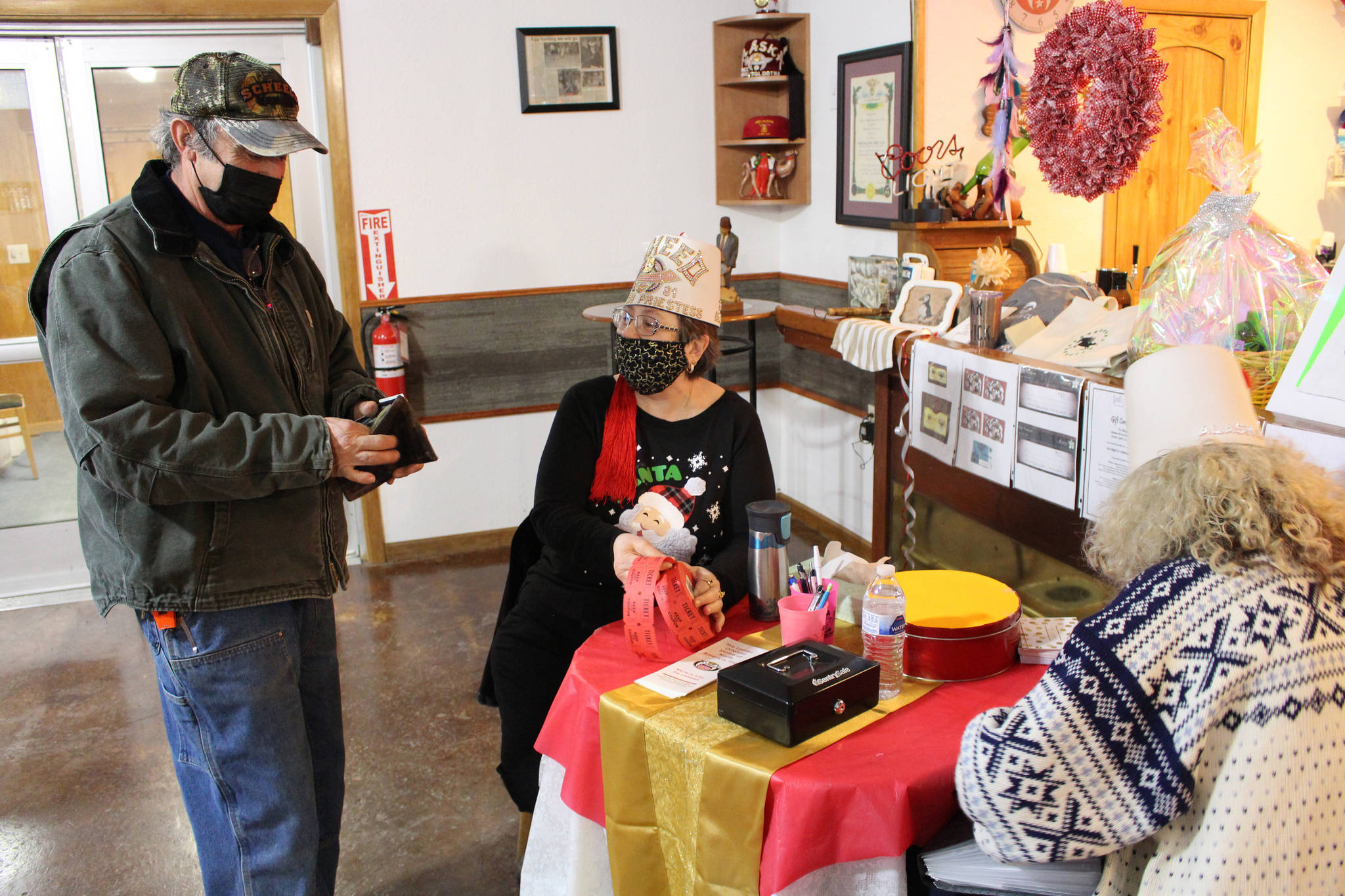 Brian Mazurek/Peninsula Clarion 
Bob Mohni, of Cooper Landing, buys door prize tickets from Cheryle James, High Priestess of the Lady Shriners of Alaska, during the inaugural Lady Shriner’s Craft Fair at the Kenai Soldotna Shrine Club on Saturday.