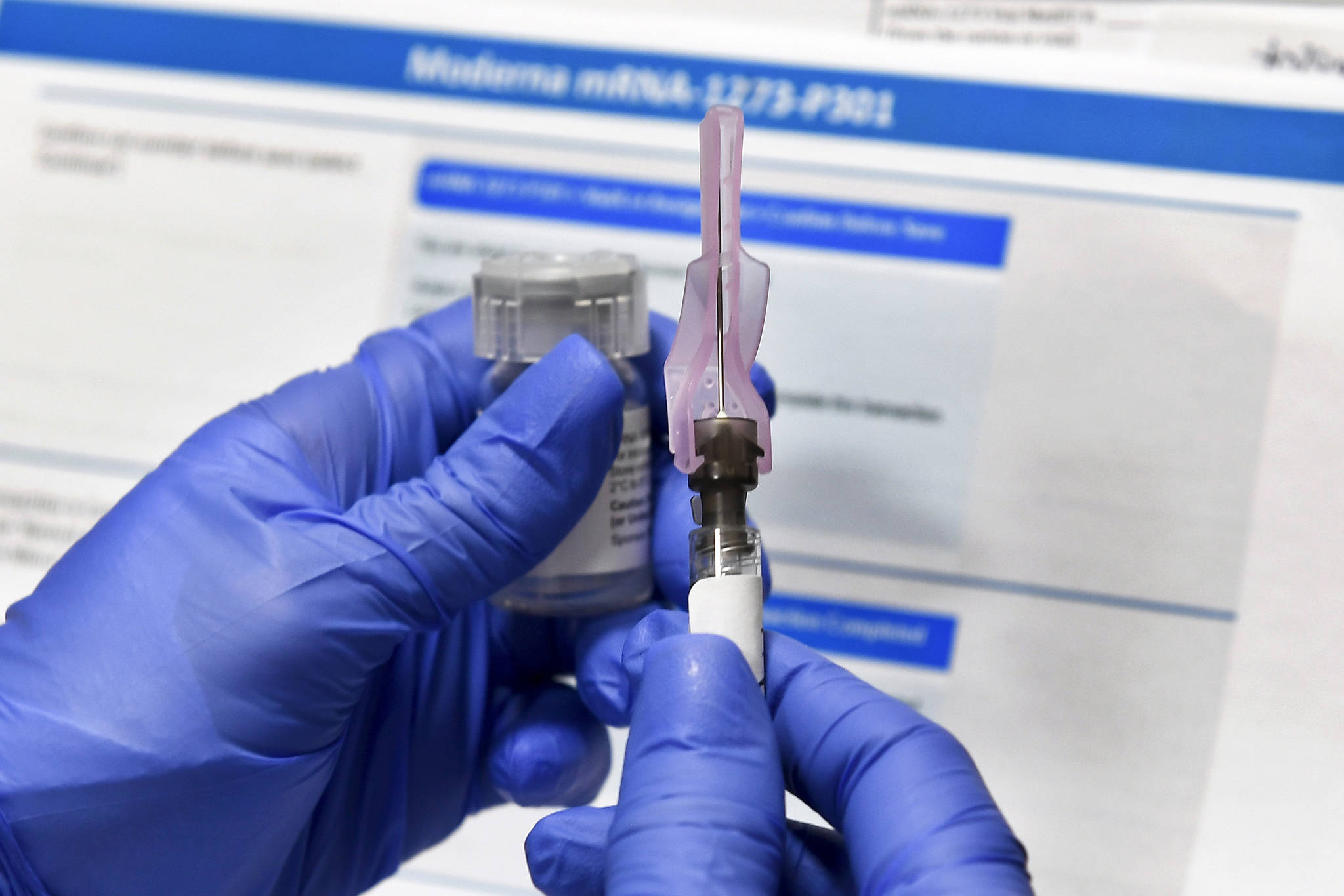 In this Monday, July 27, 2020 file photo, a nurse prepares a syringe during a study of a possible COVID-19 vaccine, developed by the National Institutes of Health and Moderna Inc., in Binghamton, N.Y. (AP Photo/Hans Pennink)