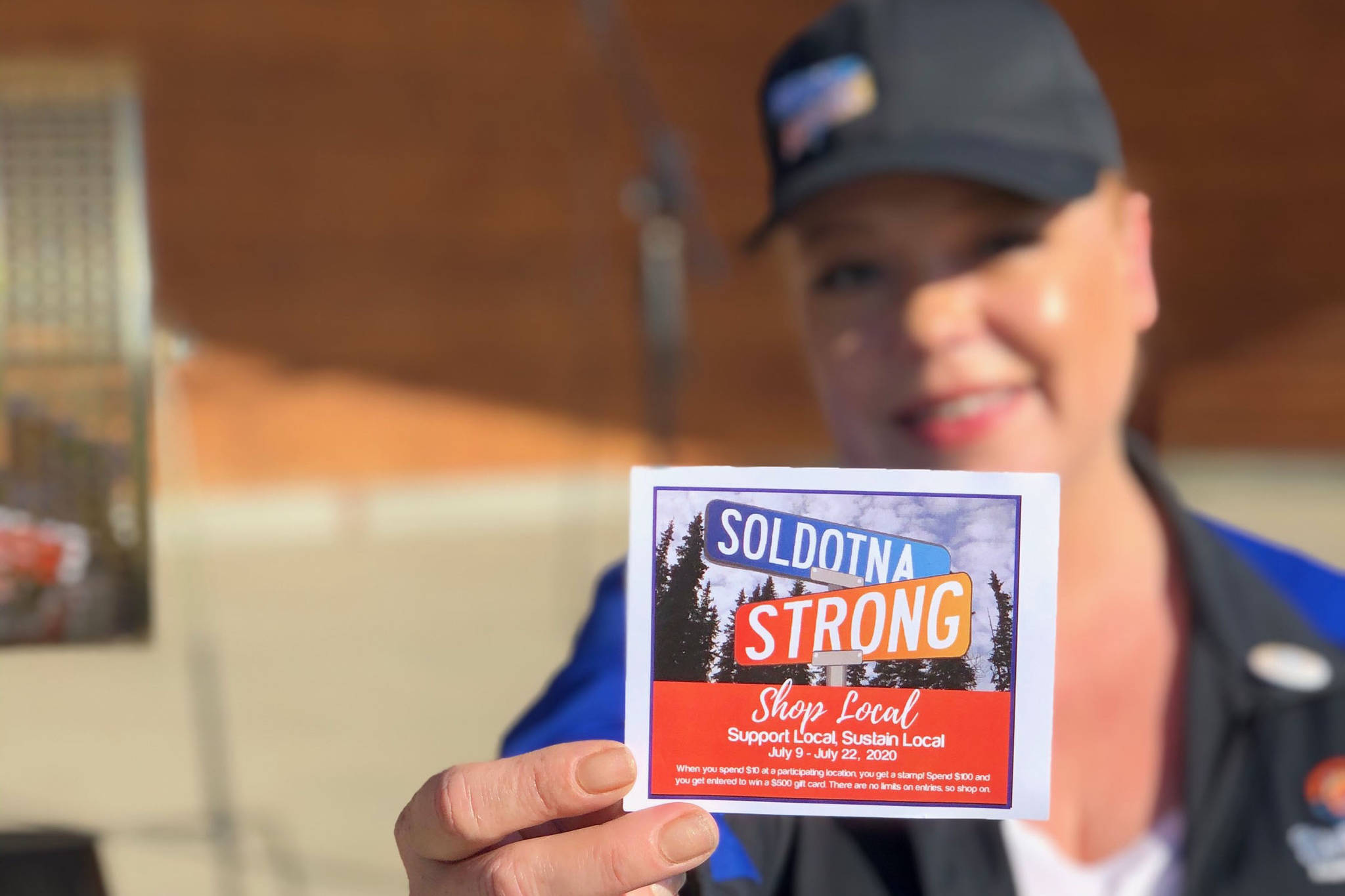 Shanon Davis, executive director of the Soldotna Chamber of Commerce, shows off a stamp card used in the chamber’s Soldotna Strong Shop Local campaign during Progress Days in Soldotna Creek Park on July 22, 2020. (Photo courtesy Shanon Davis)