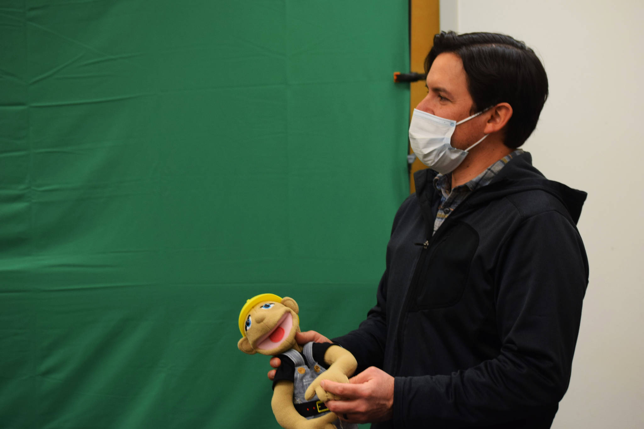 Children’s librarian James Adcox holds a puppet in front of a green screen at the Kenai Community Library on Dec. 11.