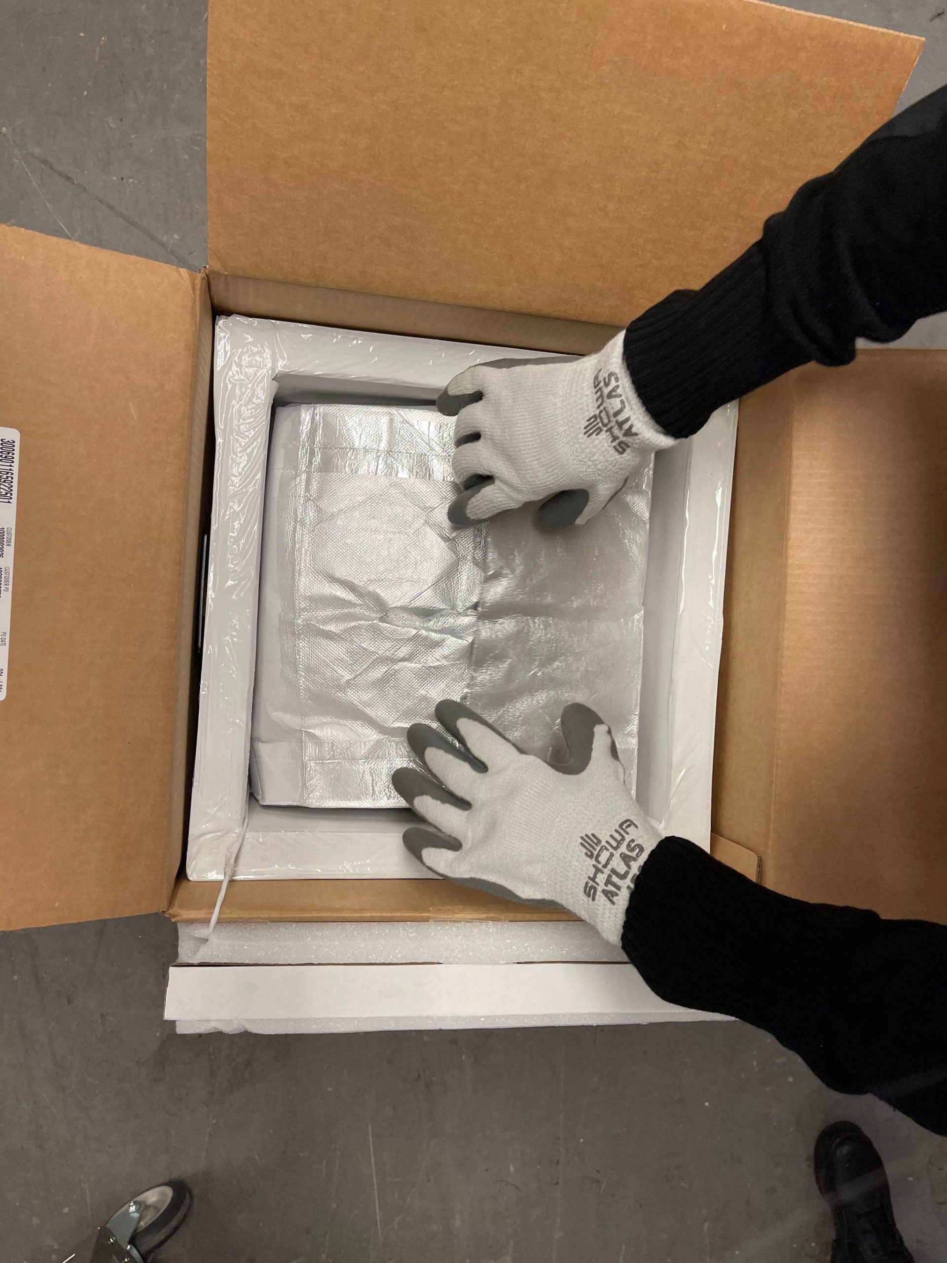 Alaska Native Medical Center Sara Doran-Atchison opens a package containing doses of Pfizer's COVID-19 vaccine at the Alaska Native Medical Center on Monday, Dec. 14, 2020 in Anchorage Alaska. (Kara King/ANMC Director of Pharmacy). Courtesy of Alaska Department of Health and Social Services.