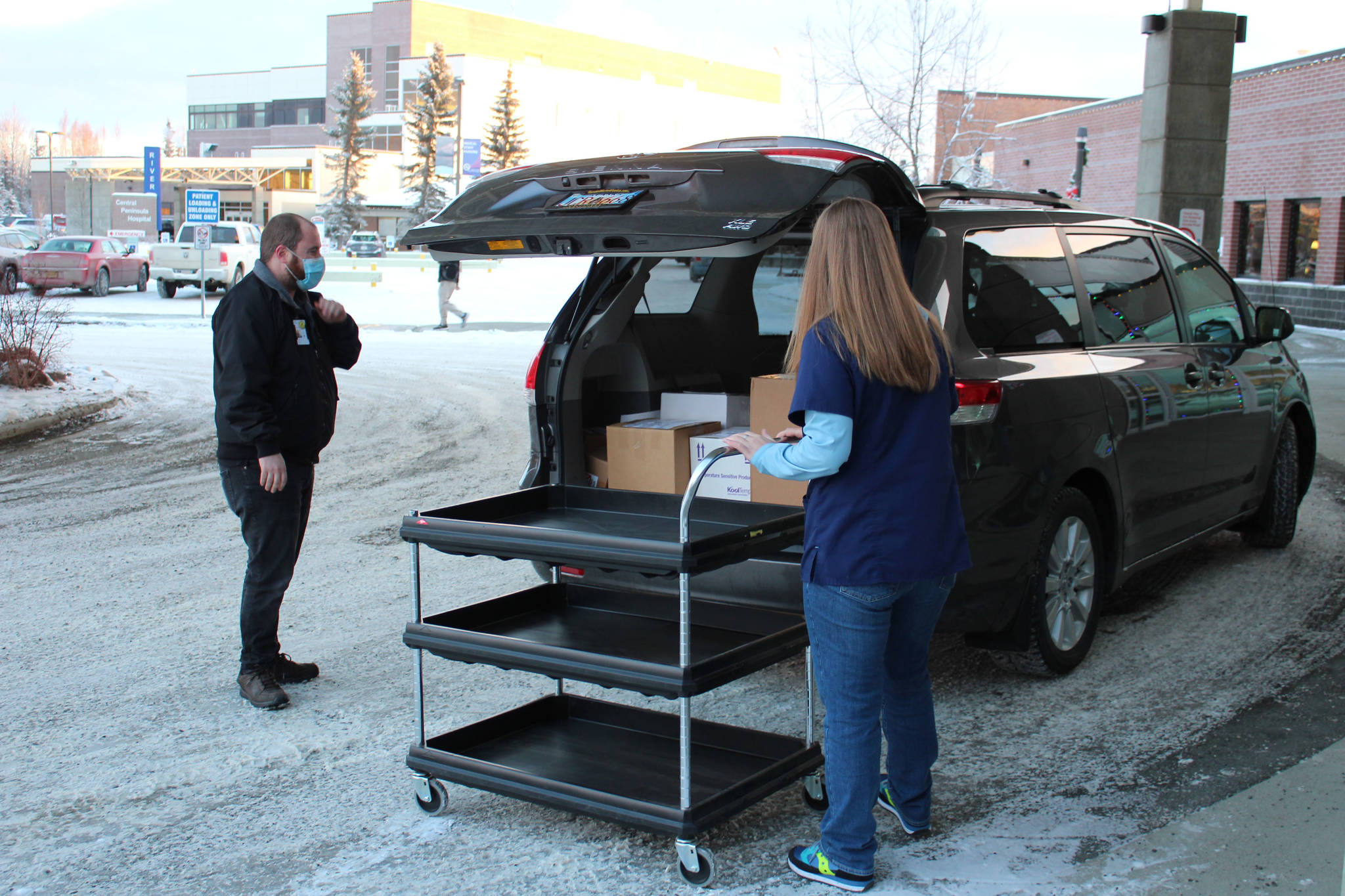 Ronald Lyon (left) and Jessica Hulet (right) prepare to offload doses of Pfizer’s COVID-19 vaccine at Central Peninsula Hospital on Wednesday, Dec. 16 in Soldotna, Alaska. (Ashlyn O’Hara/Peninsula Clarion)