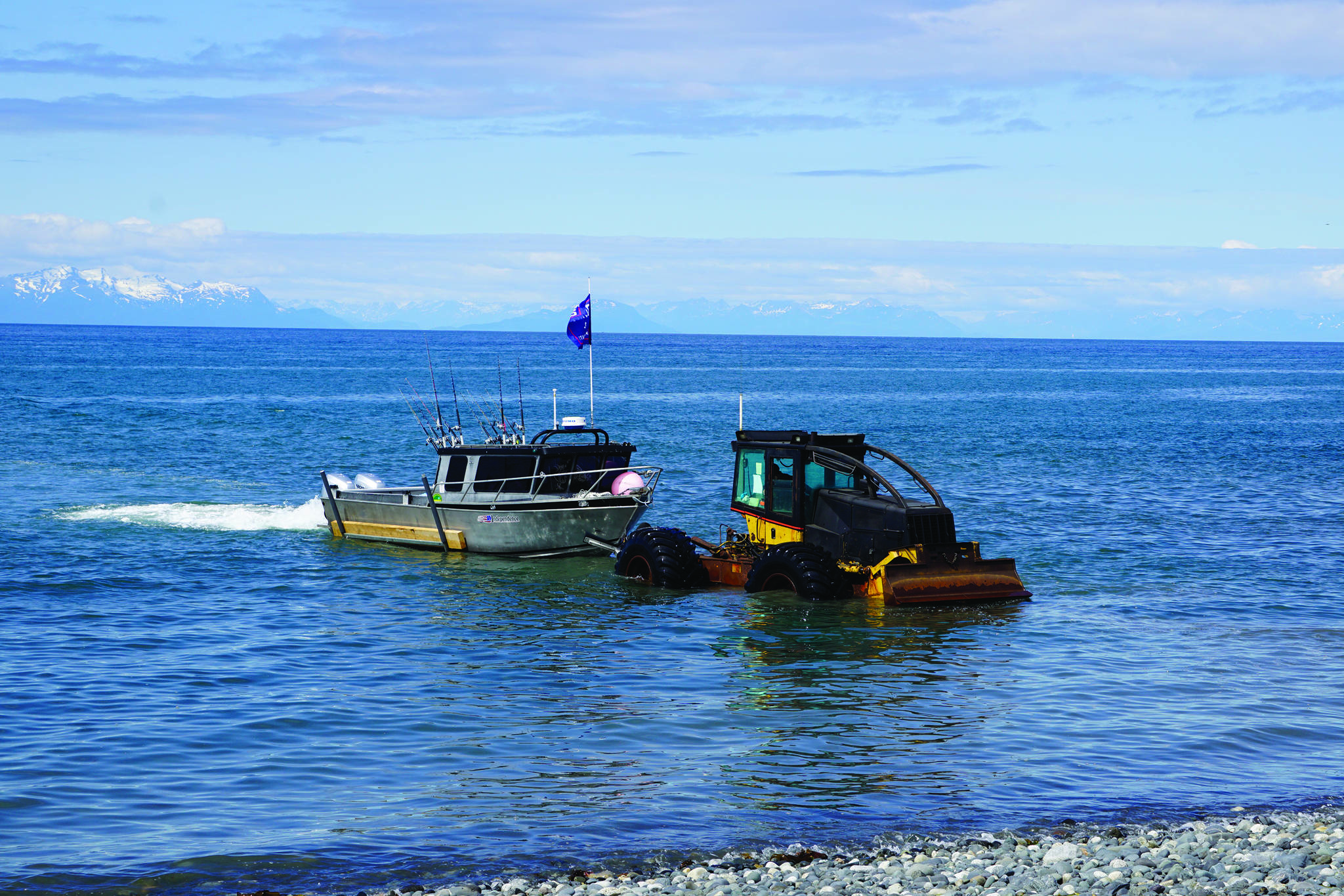 A tractor with the Anchor Point Tractor Launch pulls a fishing boat out of the water on Saturday, June 20, 2020, at the beach in Anchor Point, Alaska. (Photo by Michael Armstrong/Homer News)