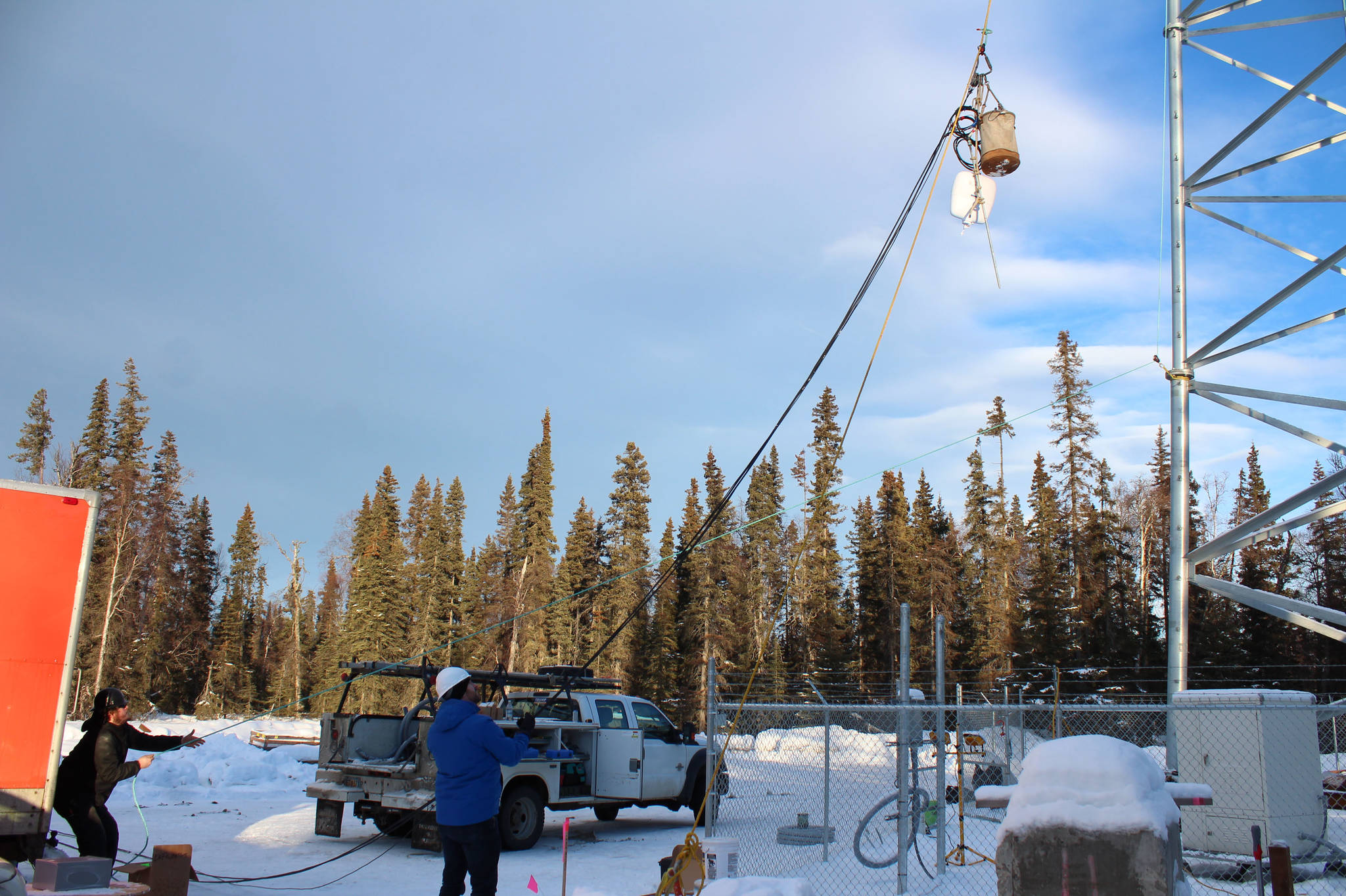 Bryan Stogsdill (left) and McKenzie McCarthy (right) hoist materials to the top of a communications tower on Thursday, Jan. 7 in Nikiski, Alaska. (Ashlyn O’Hara/Peninsula Clarion)