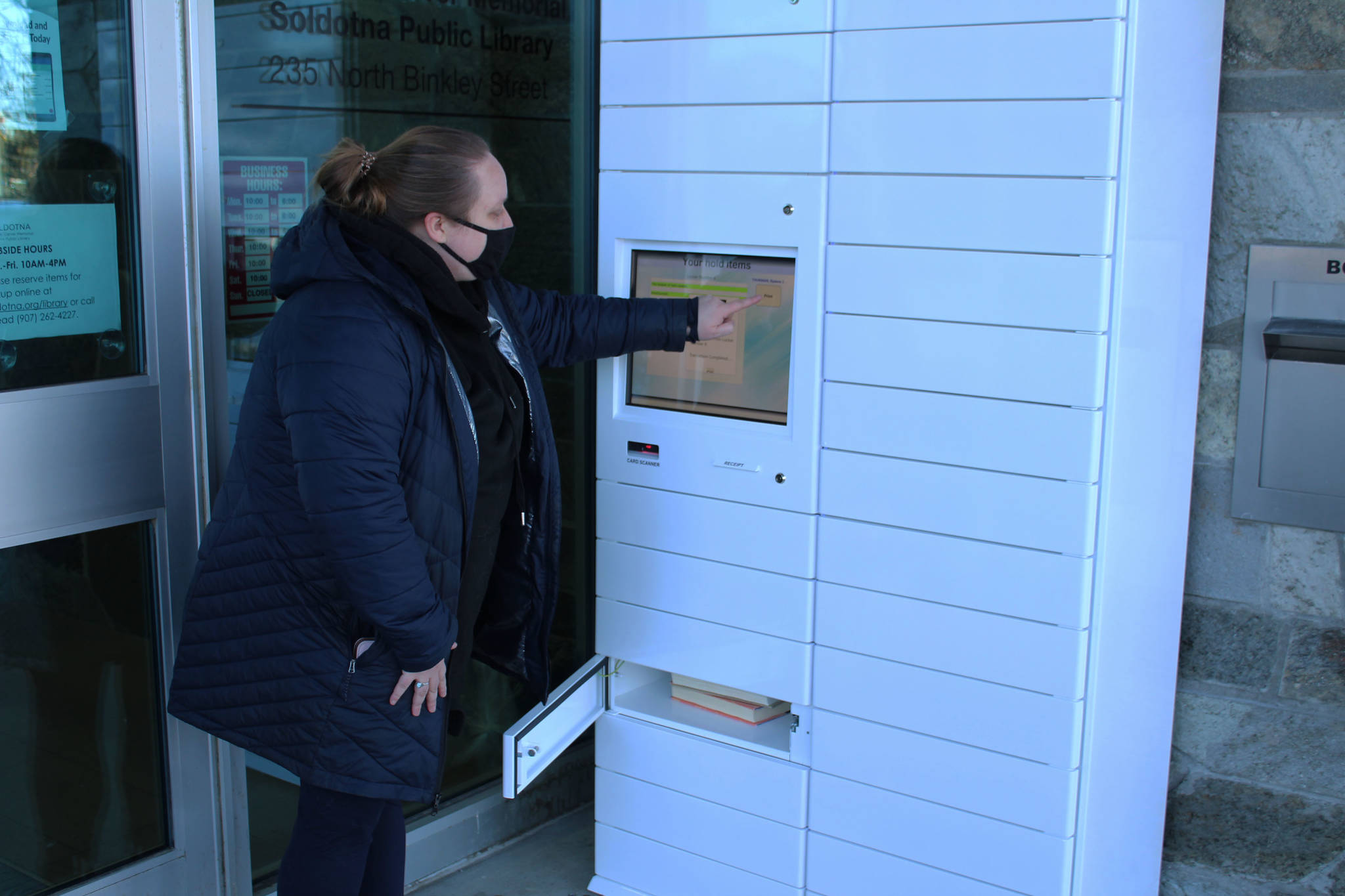 Ryanna Thurman uses a holds locker at the Soldotna Public Library on Friday, Jan. 15 in Soldotna, Alaska. (Ashlyn O’Hara/Peninsula Clarion)