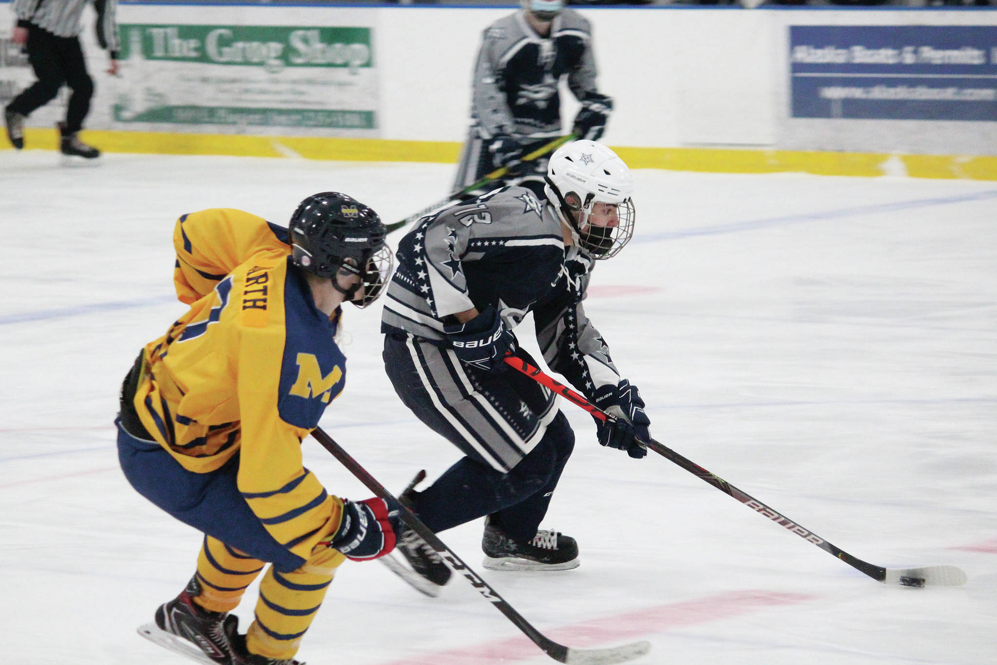 Soldotna’s Aiden Burcham controls the puck under pressure from Homer’s Brock Barth during a Saturday, Jan. 23, 2021 hockey game between the two schools at Kevin Bell Arena in Homer, Alaska. (Photo by Megan Pacer/Homer News)