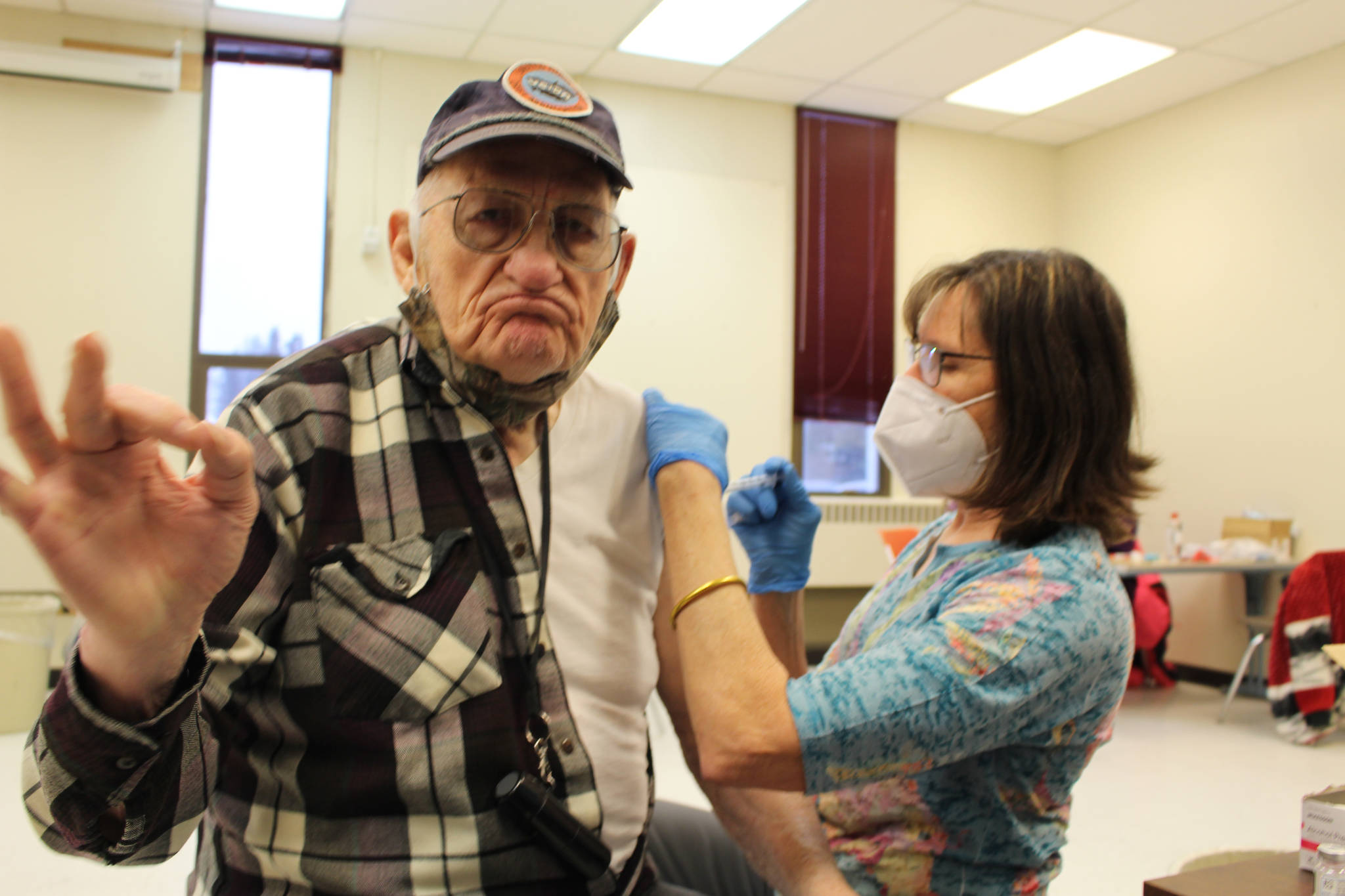 Retired school nurse Tracy Silta adminsters the COVID-19 vaccine to Raymond Schoessler at the Soldotna Prep School in Soldotna, Alaska on Jan. 23, 2021. (Photo by Brian Mazurek/Peninsula Clarion)