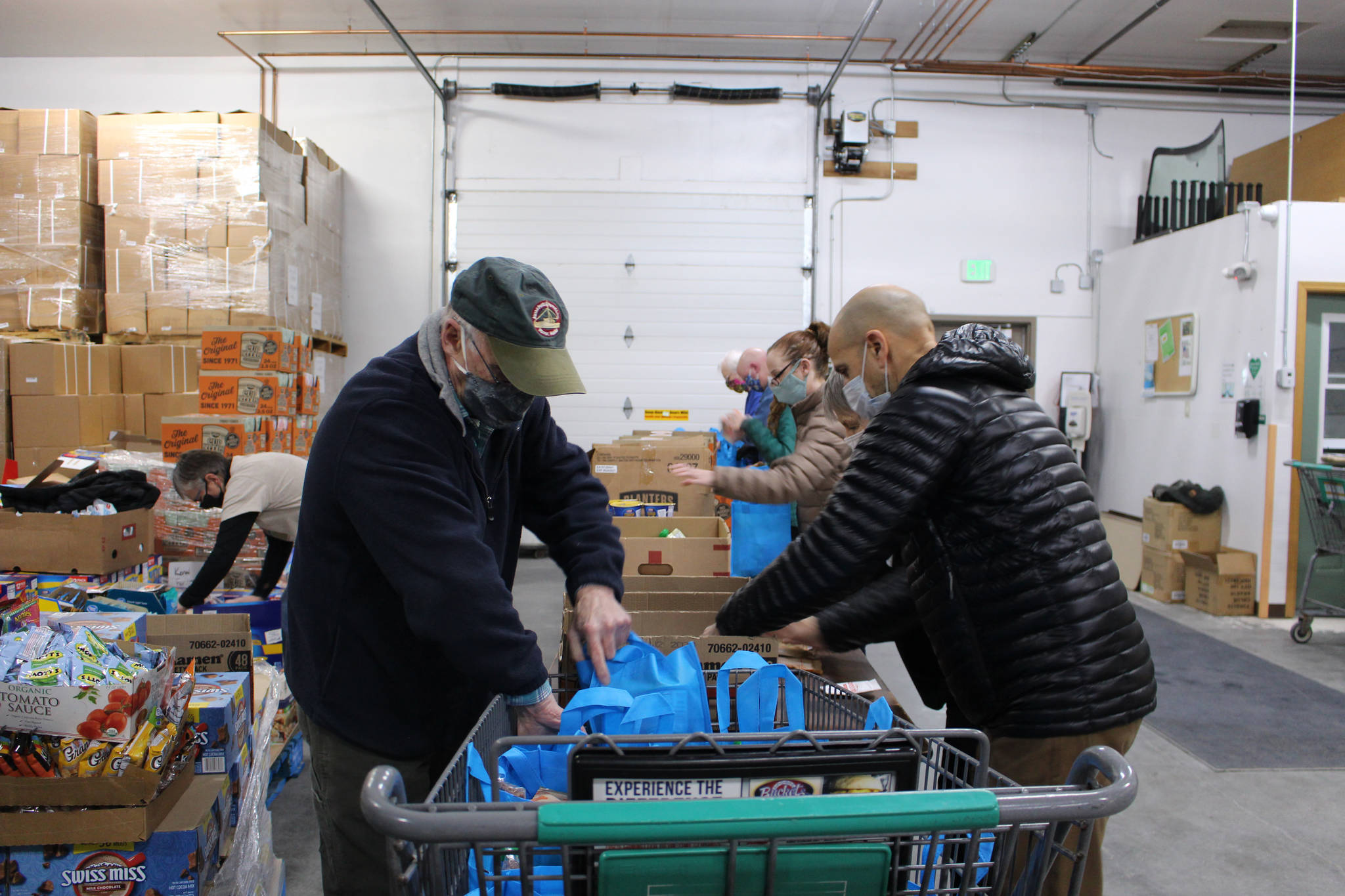 Volunteers Bill Kelley and Frank Alioto prepare bags of food to be distributed during the upcoming Project Homeless Connect even at the Kenai Peninsula Food Bank in Soldotna, Alaska on Jan. 23, 2021. (Photo by Brian Mazurek/Peninsula Clarion)