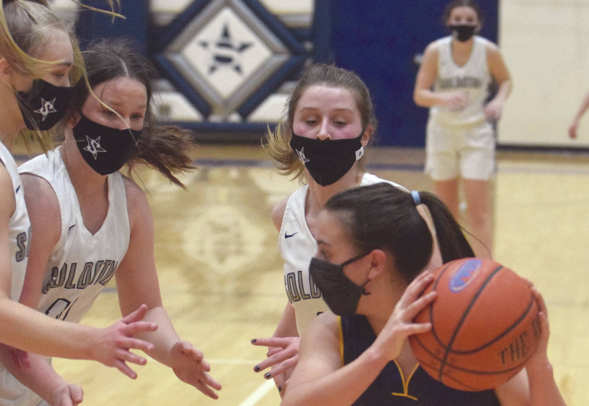Homer's Sailey Rhodes confronts a trap of Soldotna's Jolie Widaman, Josie Sheridan and Rhys Cannava on Tuesday, Jan. 26, 2021, at Soldotna High School in Soldotna, Alaska. (Photo by Jeff Helminiak/Peninsula Clarion)