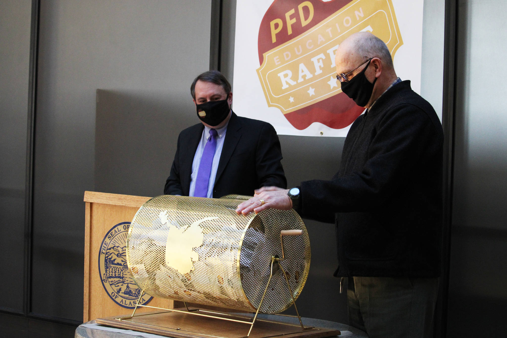Ben Hohenstatt / Juneau Empire
State Sen. Click Bishop (right) prepares to draw a name from the barrel Wednesday during the second annual Permanent Fund Dividend Education Raffle while Department of Revenue deputy commissioner Mike Barnhill watches in the State Office Building.