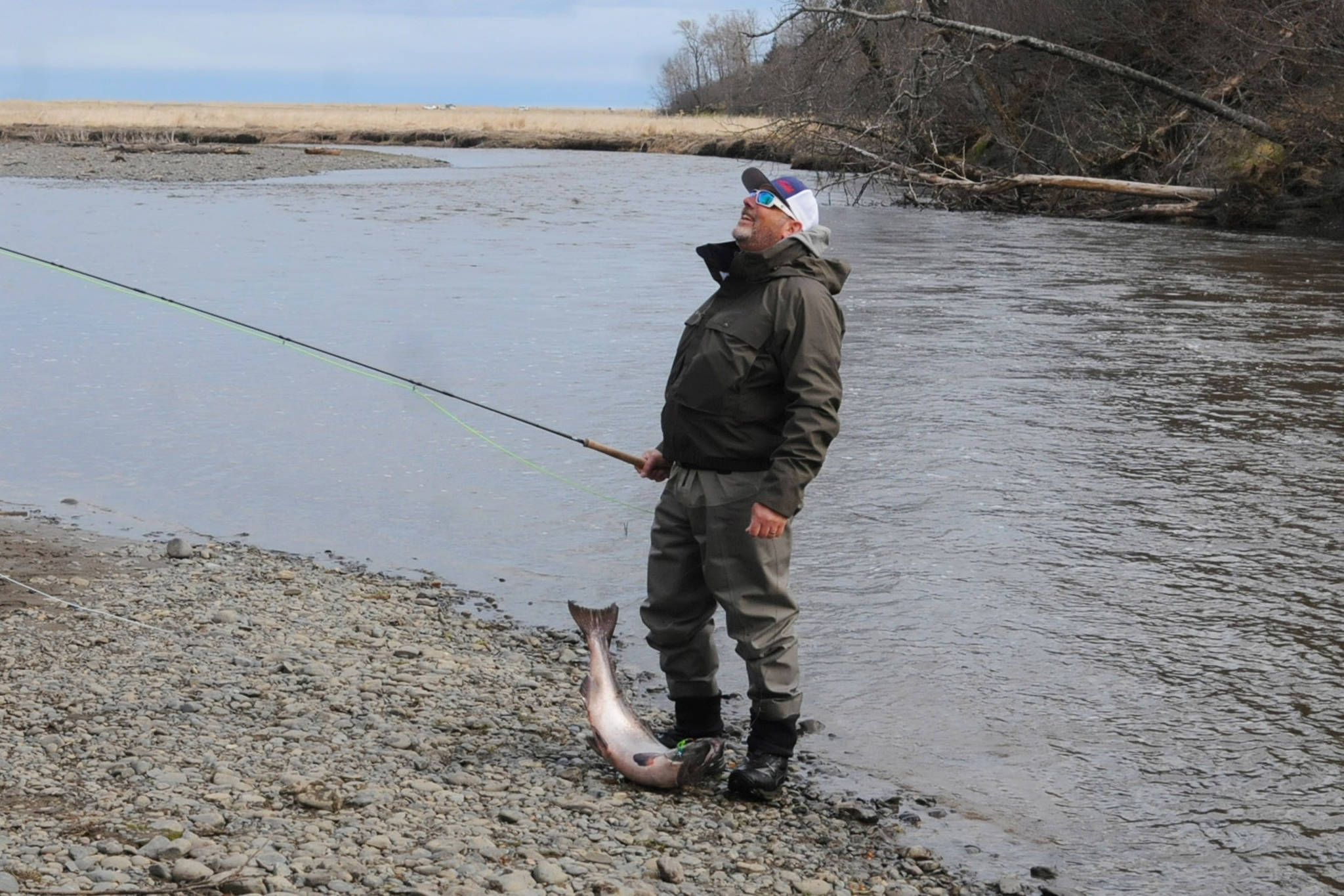 Terry Umatum of Anchorage takes a deep breath after landing his Anchor River king salmon on Saturday, May 19, 2018 in Anchor Point, Alaska. (Peninsula Clarion file)