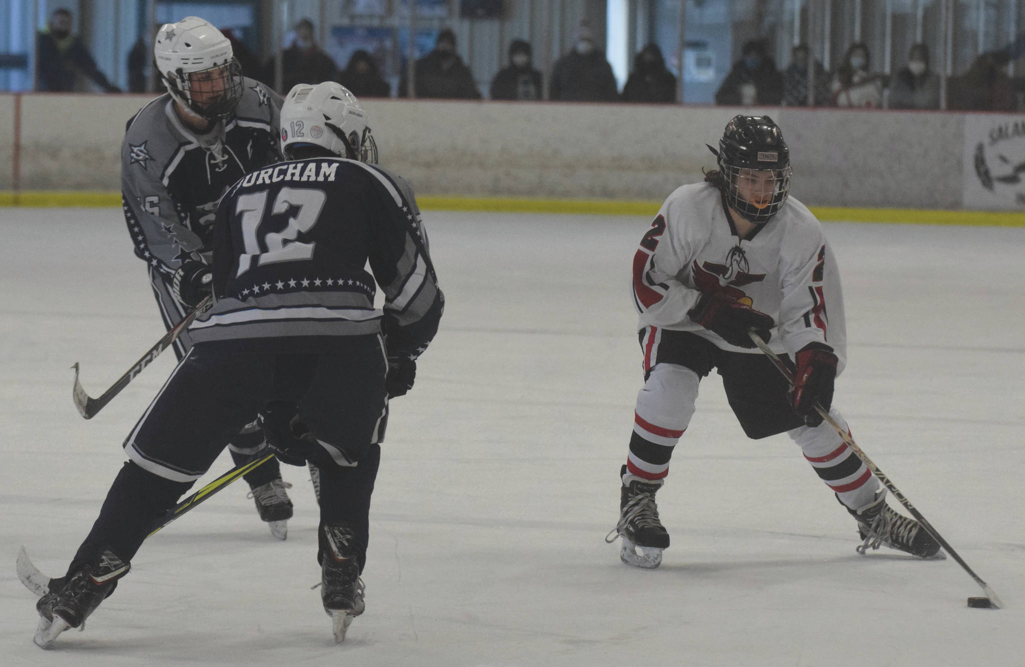 Kenai Central’s Cooper Stock gains the zone against Soldotna’s Dylan Walton and Aiden Burcham on Saturday, Feb. 13, 2021, at the Kenai Multi-Purpose Facility in Kenai, Alaska. (Photo by Jeff Helminiak/Peninsula Clarion)