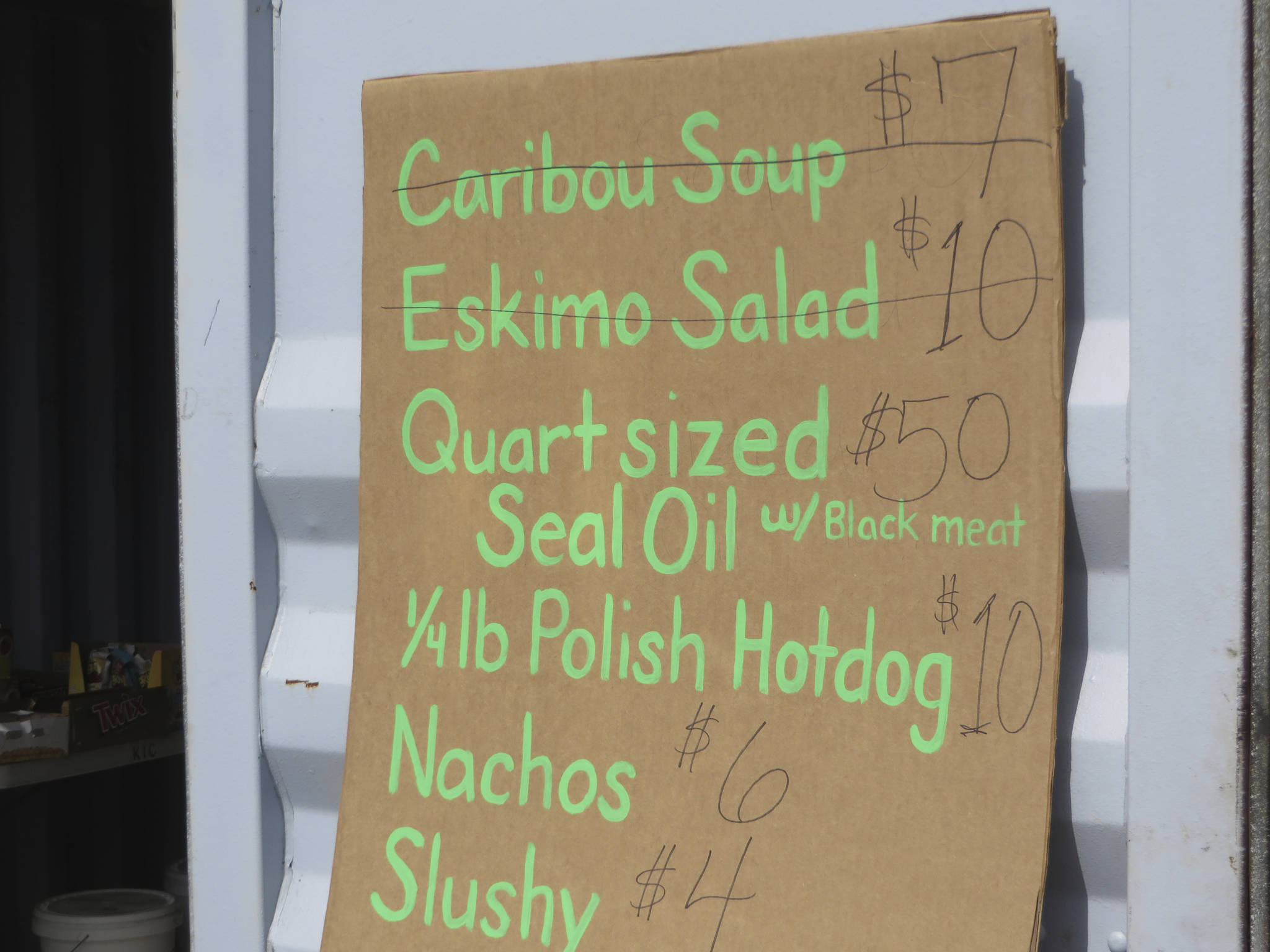 This July 4, 2014, photo provided by Val Kreil shows a restaurant menu of food for sale, including Caribou soup, Eskimo Salad and Seal Oil at the community fairgrounds in Kotzebue, Alaska. The Maniilaq Health Association in the Chukchi Sea community of Kotzebue has received state approval to process and serve seal oil at its elder care facility in Kotzebue, believed to be a first for seal oil in the U.S. (Val Kreil via AP)