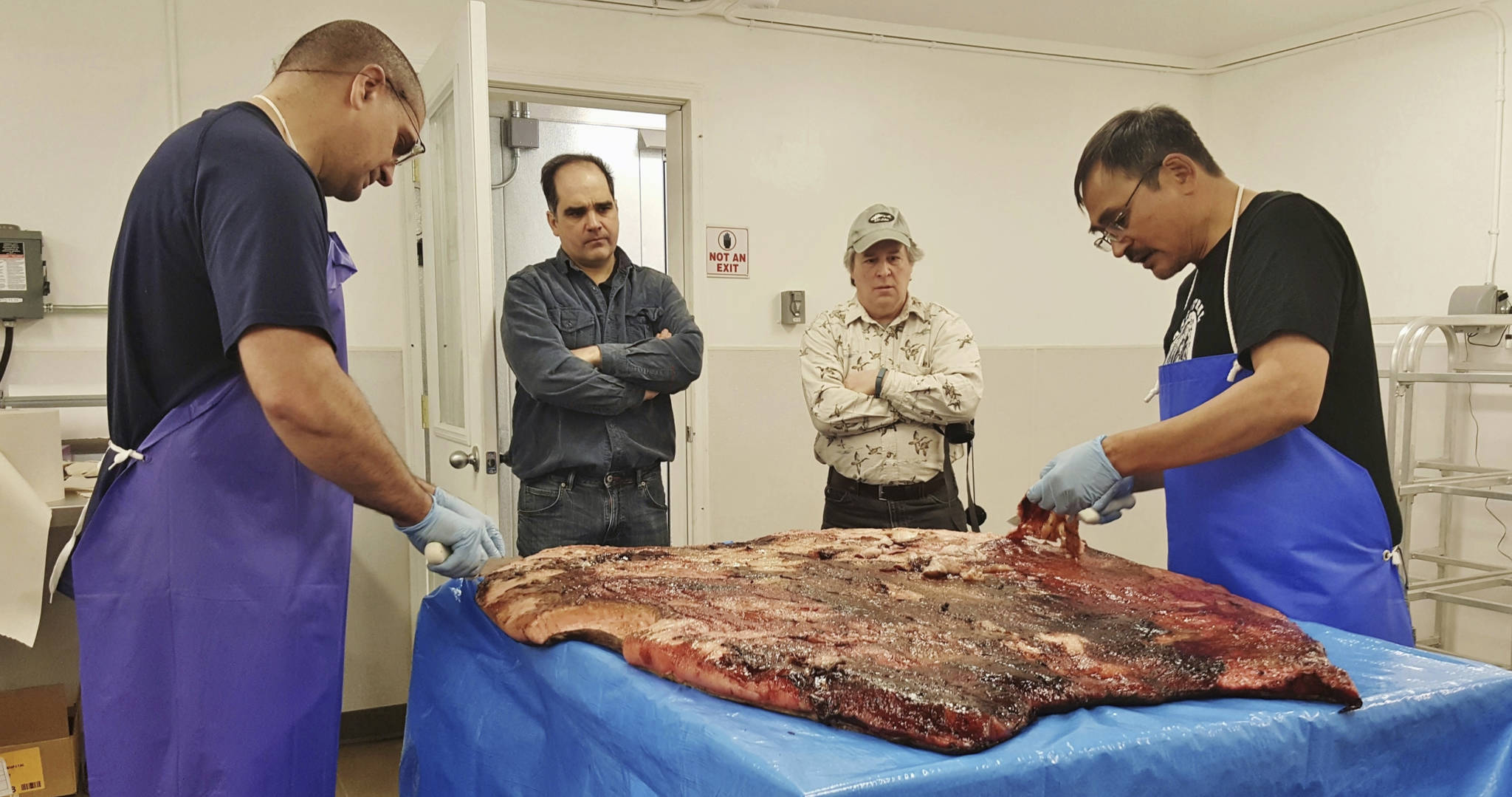 Maniilaq Association via AP
Alex Whiting, left, and Cyrus Harris, right, are observed by Chris Sannito, second from left, and Brian Himelbloom, third from left, of the Kodiak Seafood and Marine Science Center as they trim and clean seal blubber in Kotzebue.