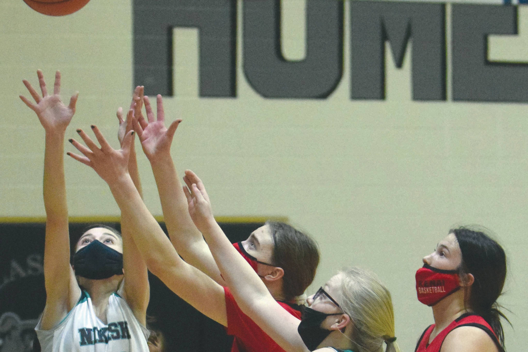 Nikiski's Rylee Ellis and Avery White and Kenai Central's Erin Koziczkowski and Amber Nash battle for the rebound Thursday, Feb. 16, 2021, at Nikiski High School in Nikiski, Alaska. (Photo by Jeff Helminiak/Peninsula Clarion)