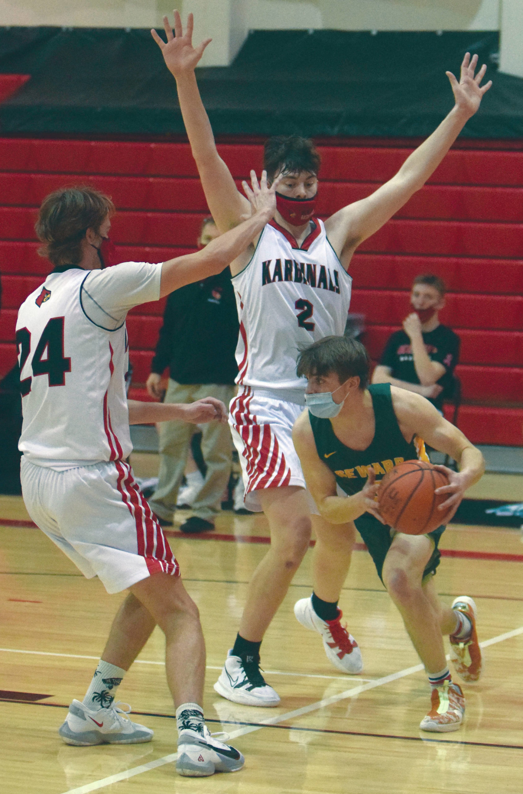 Seward’s Sam Koster looks for a way around Kenai Central’s Lucas Tunseth and Keagen Medina on Thursday, Feb. 18, 2021, at Kenai Central High School in Kenai, Alaska. (Photo by Jeff Helminiak/Peninsula Clarion)