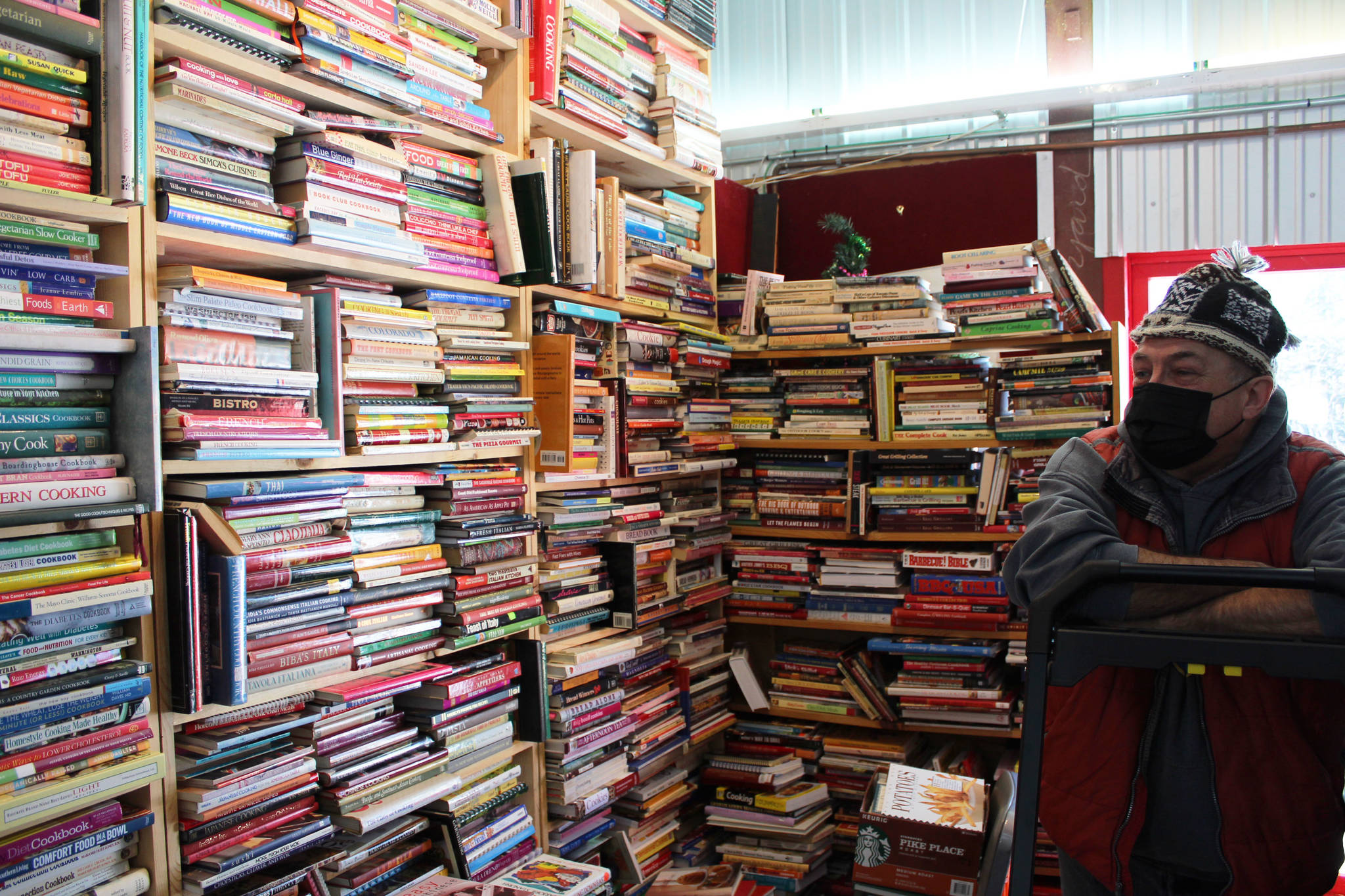 Benjamin Jackinsky stands next to bookshelves inside of Already Read on Friday, Feb. 19 in Kenai, Alaska. (Ashlyn O’Hara/Peninsula Clarion)
