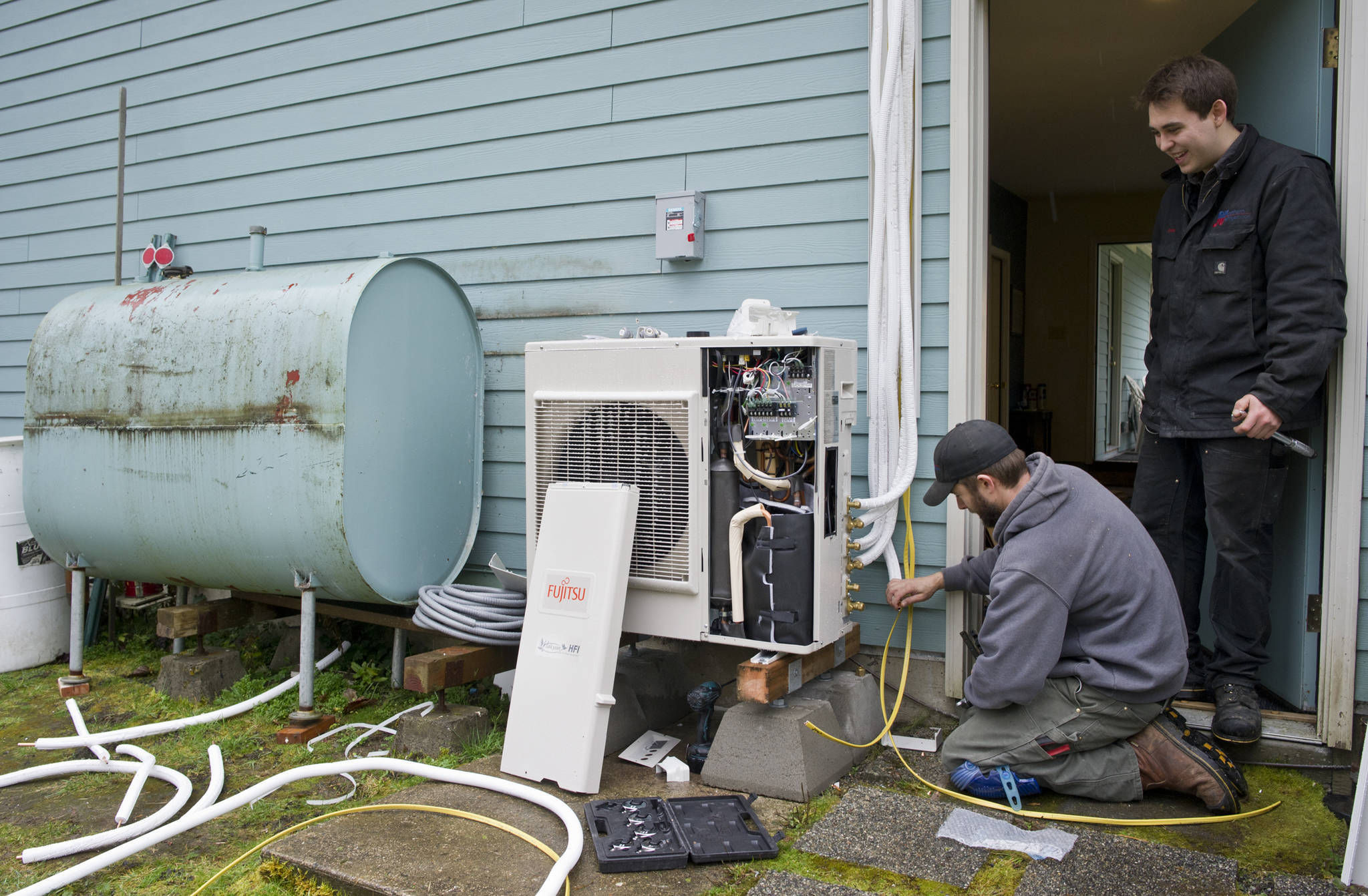 Michael Penn / Juneau Empire file
Air-source heat pumps, like the one in this 2015 photo of Jake Eames, right, and David Nash installing a pump, are an example of a load-side technology that can increase energy efficiency. “Load-side technologies are absolutely key to our ability to reduce greenhouse emissions in the energy sector,” said director of energy services at Alaska Electric Light and Power Alec Mesdag.