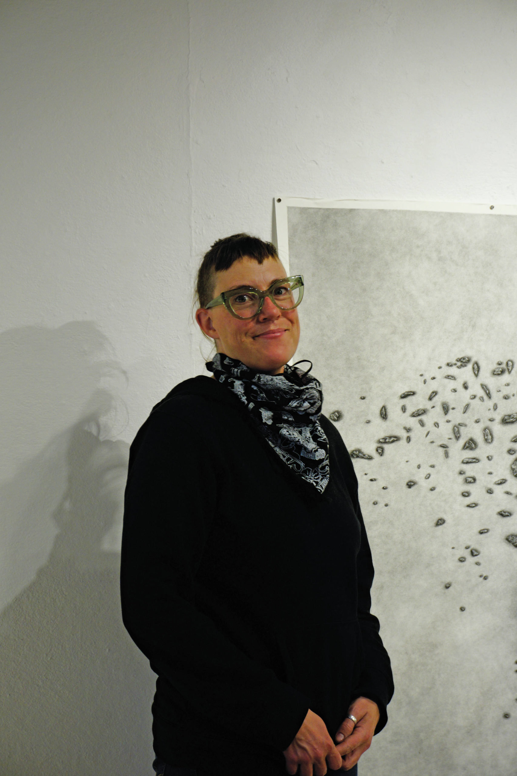Michael Armstrong / Homer News
Bunnell Street Arts Center Artist in Residence Nina Elder stands next to a drawing from her series, “It Will Not Be the Same, But It Might Be Beautiful,” drawings of puzzle stones collected in the area near McCarthy.