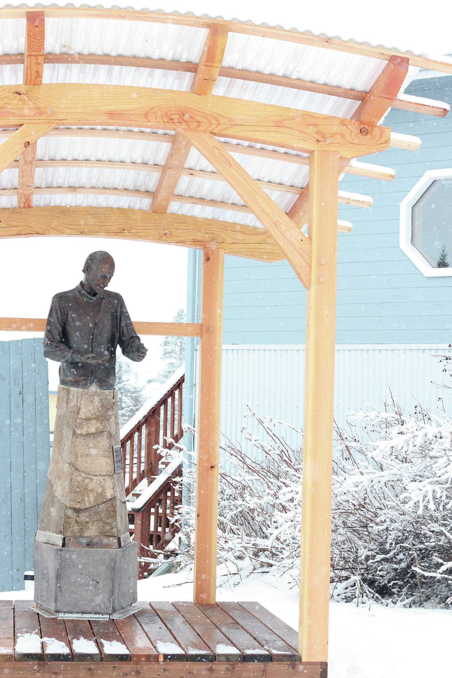 A statue of Brother Asaiah rests under a protective wooden structure on Thursday, Feb. 18, 2021 outside KBBI Public Radio in Homer, Alaska. (Photo by Megan Pacer/Homer News)