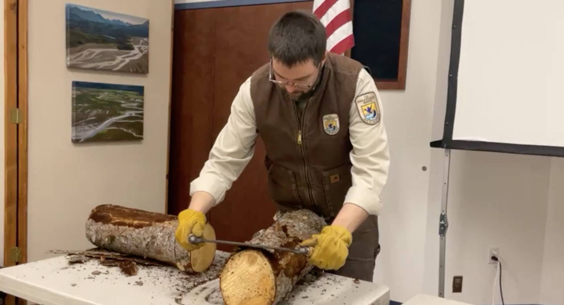 Daniel Saxton demonstrates how to use a draw knife during the Kenai Wildlife Refuge’s remote Speaker Series on cabins on Friday, Feb. 26 in Kenai, Alaska. (Screenshot)