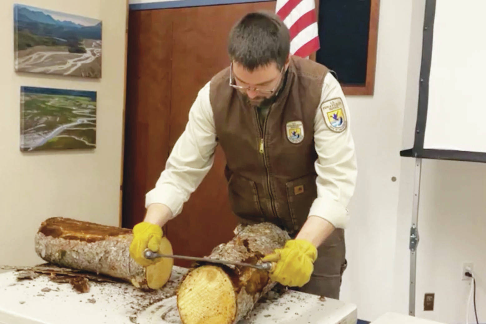 Daniel Saxton demonstrates how to use a draw knife during the Kenai Wildlife Refuge’s remote Speaker Series on cabins on Friday, Feb. 26 in Kenai, Alaska. (Screenshot)