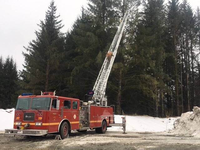 Courtesy photo / CCFR
J.D. McComas, a wildlife specialist with Juneau International Airport, climbs a Capital City Fire/Rescue ladder truck to rescue a bald eagle trapped in a tree on March 1, 2021.