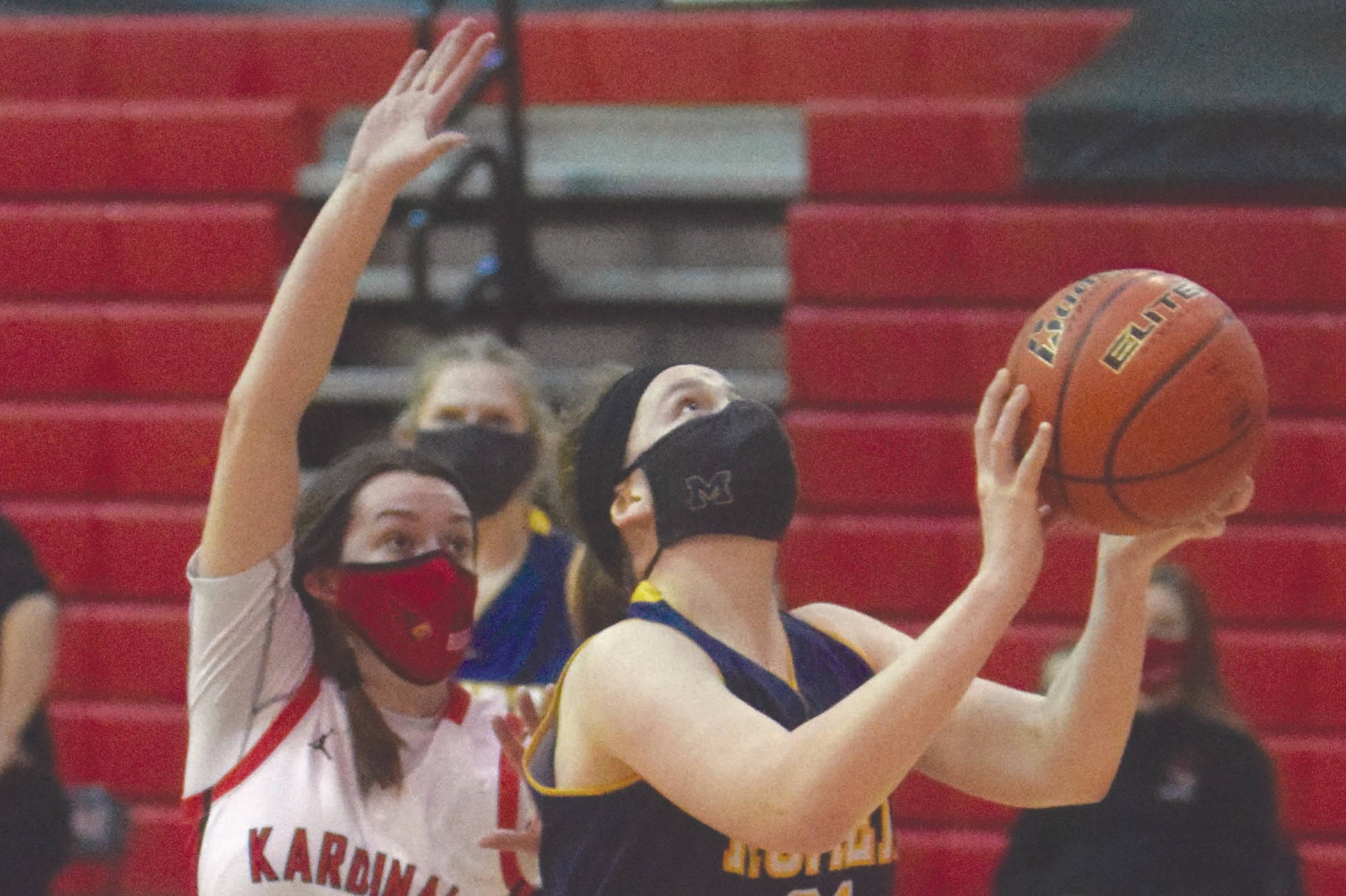 Homer’s Sophie Ellison drives to the basket against Kenai Central’s Logan Satathite on Thursday, March 4, 2021, at Kenai Central High School in Kenai, Alaska. (Photo by Jeff Helminiak/Peninsula Clarion)