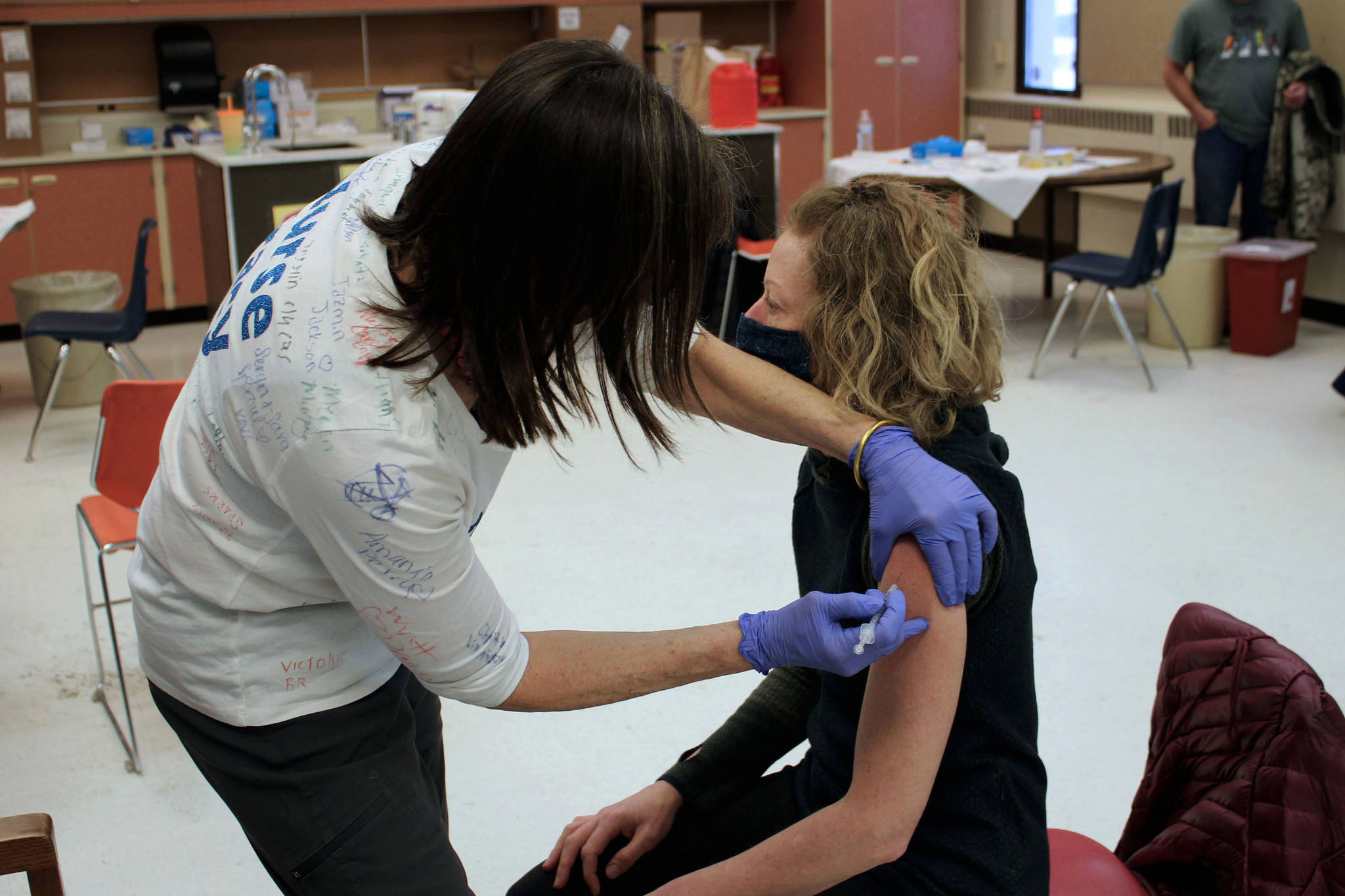 Tracy Silta (left) administers a dose of a COVID-19 vaccine to Melissa Linton during a vaccine clinic at Soldotna Prep School on Friday, Feb. 26 in Soldotna, Alaska. (Ashlyn O’Hara/Peninsula Clarion)