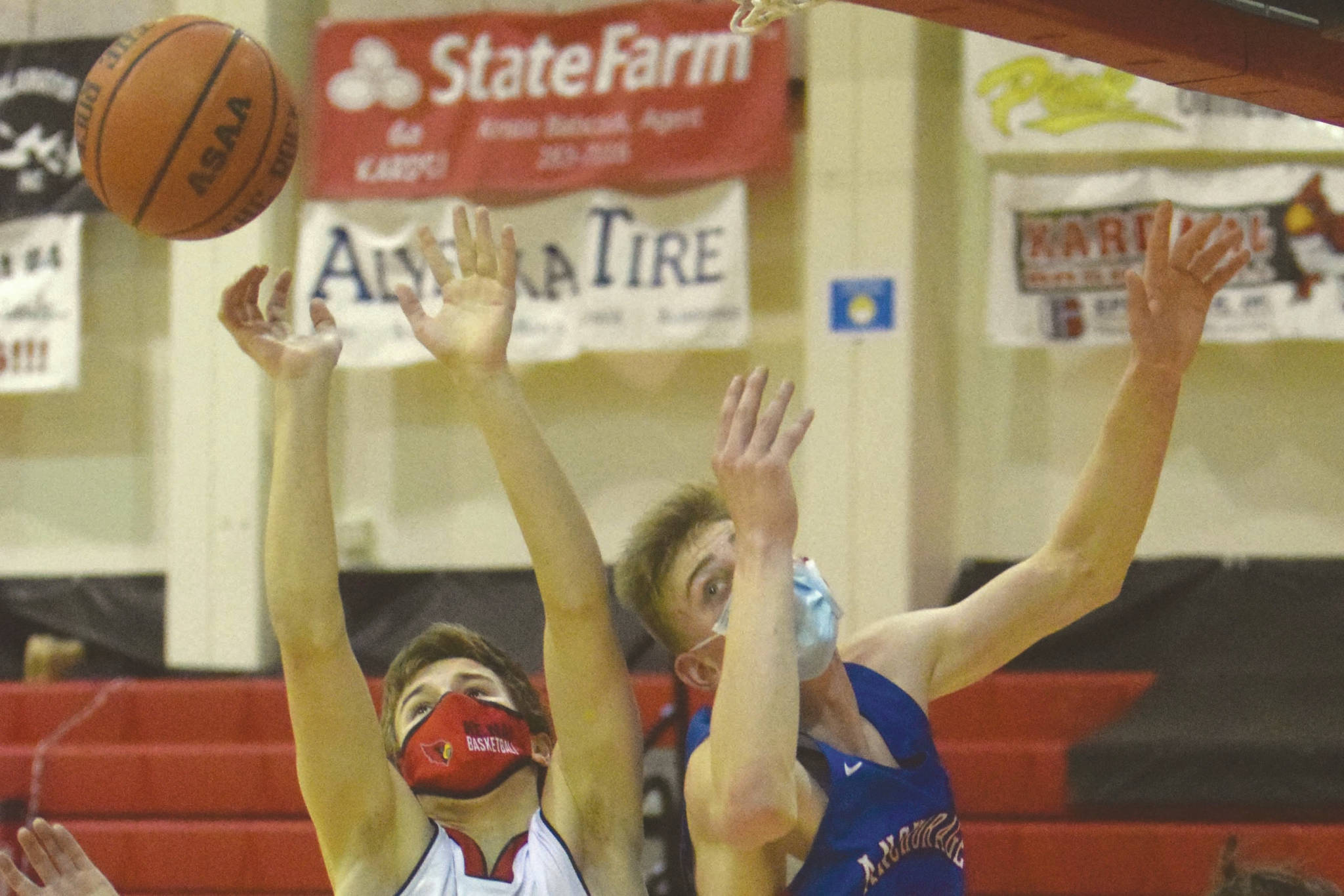 Kenai Central's Bridger Beck and Anchorage Christian Schools' Matt Sanders battle for the rebound at the Southcentral Conference tournament Thursday, March 11, 2021, at Kenai Central High School in Kenai, Alaska. (Photo by Jeff Helminiak/Peninsula Clarion)