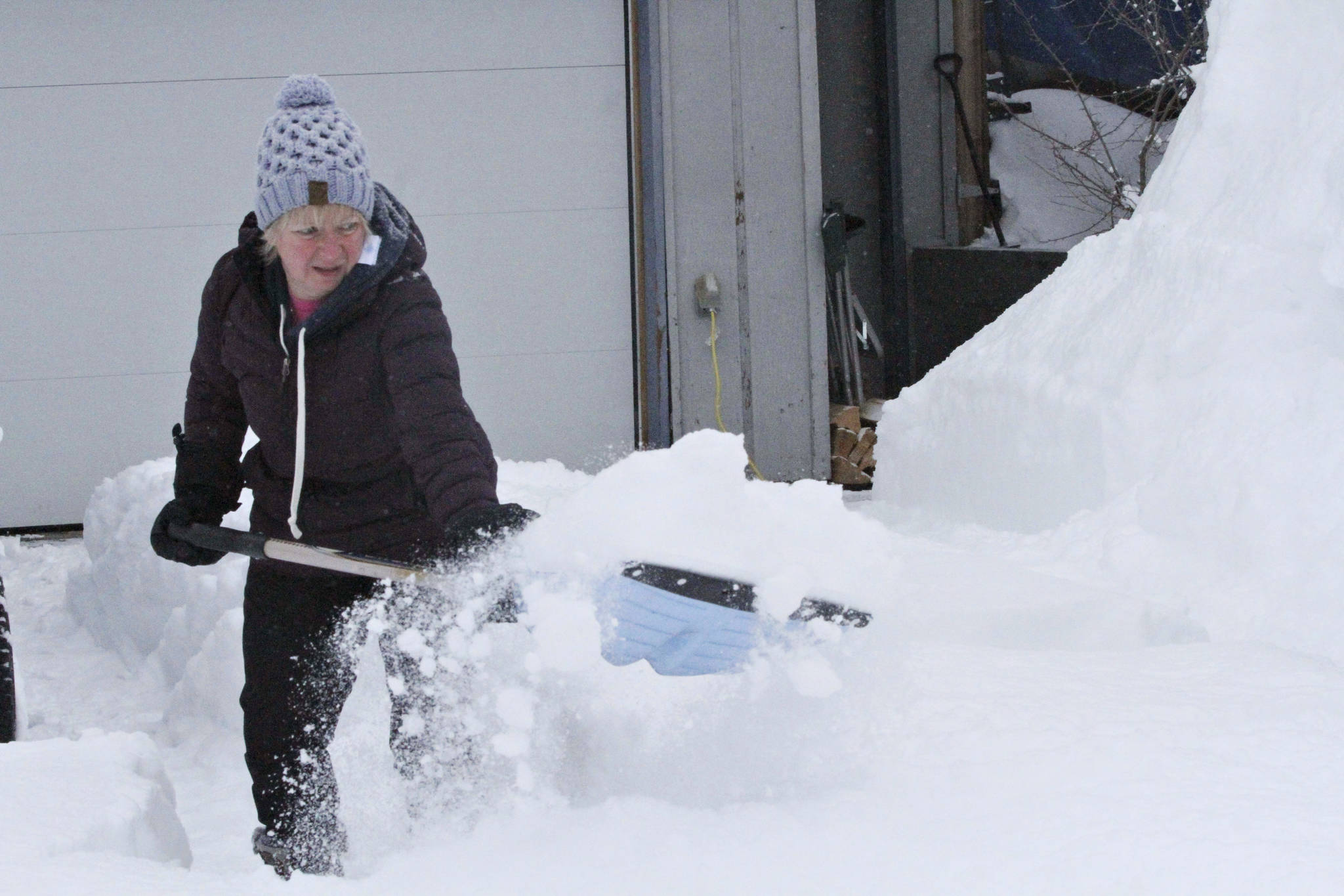 Judi Westfall shovels snow at her home in Anchorage, Alaska, on Thursday, March 11, 2021. Residents in some parts of Alaska’s largest city woke Thursday to a surprise: up to 18 new inches of snow. (AP Photo/Mark Thiessen)