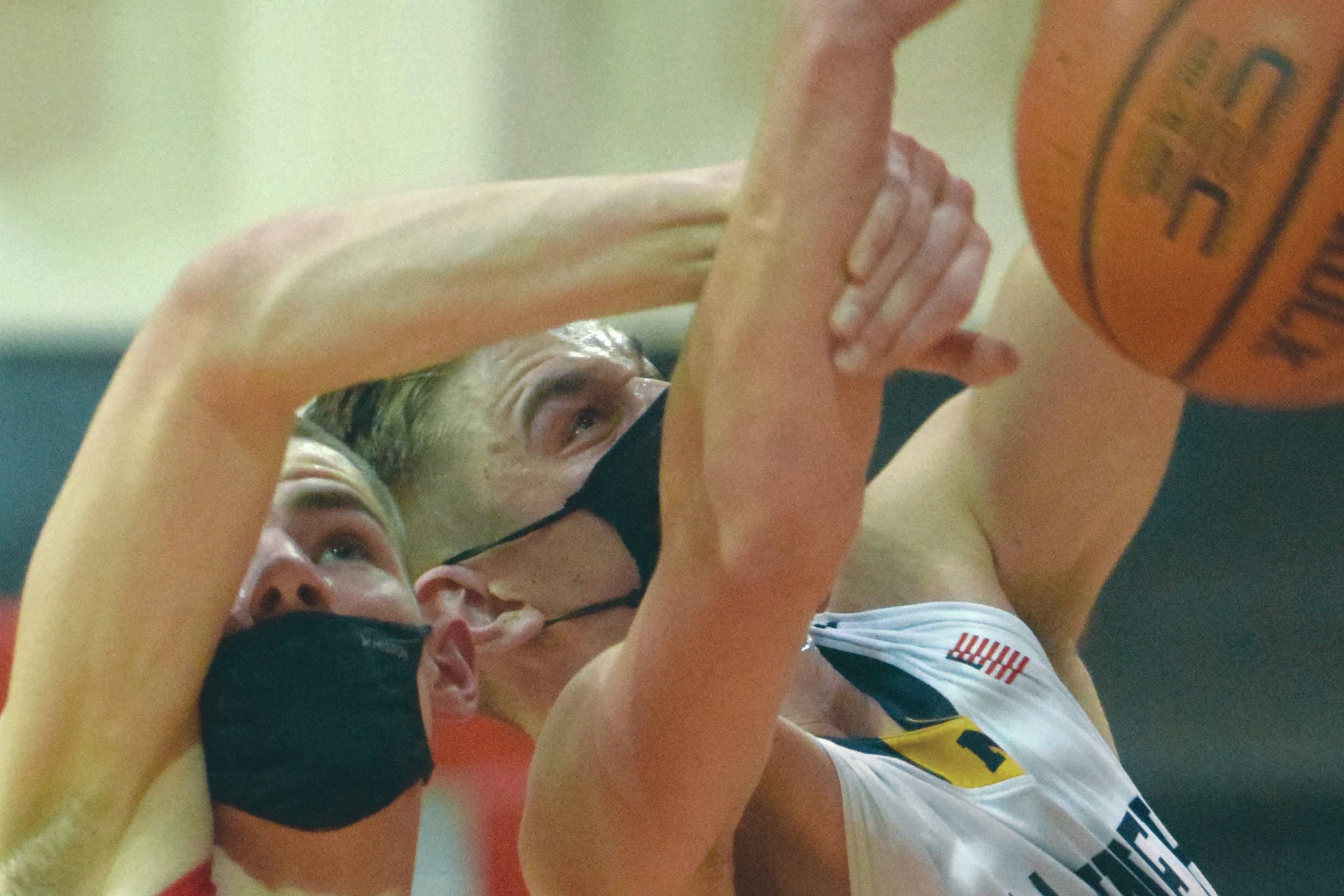 Houston's Hunter Jefferson and Homer's Clayton Beachy battle for the rebound Saturday, March 13, 2021, in the third-place game of the Southcentral Conference boys tournament at Kenai Central High School in Kenai, Alaska. (Photo by Jeff Helminiak/Peninsula Clarion)