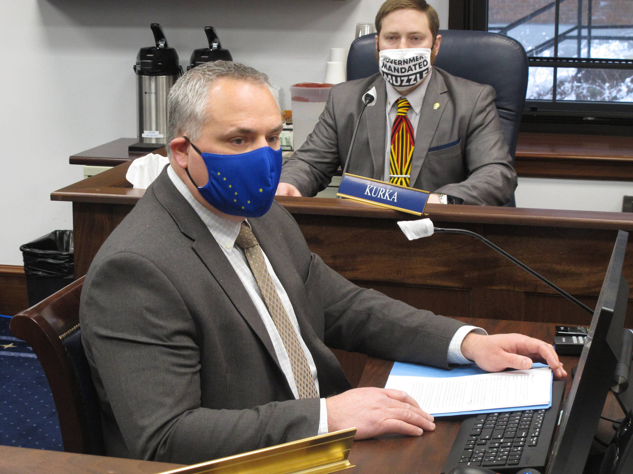 Alaska Attorney General Treg Taylor, foreground, appears before the House Judiciary Committee for a confirmation hearing on Monday, March 15, 2021, in Juneau, Alaska. Republican Rep. Christopher Kurka, a committee member, is seen in the background. (AP Photo/Becky Bohrer)