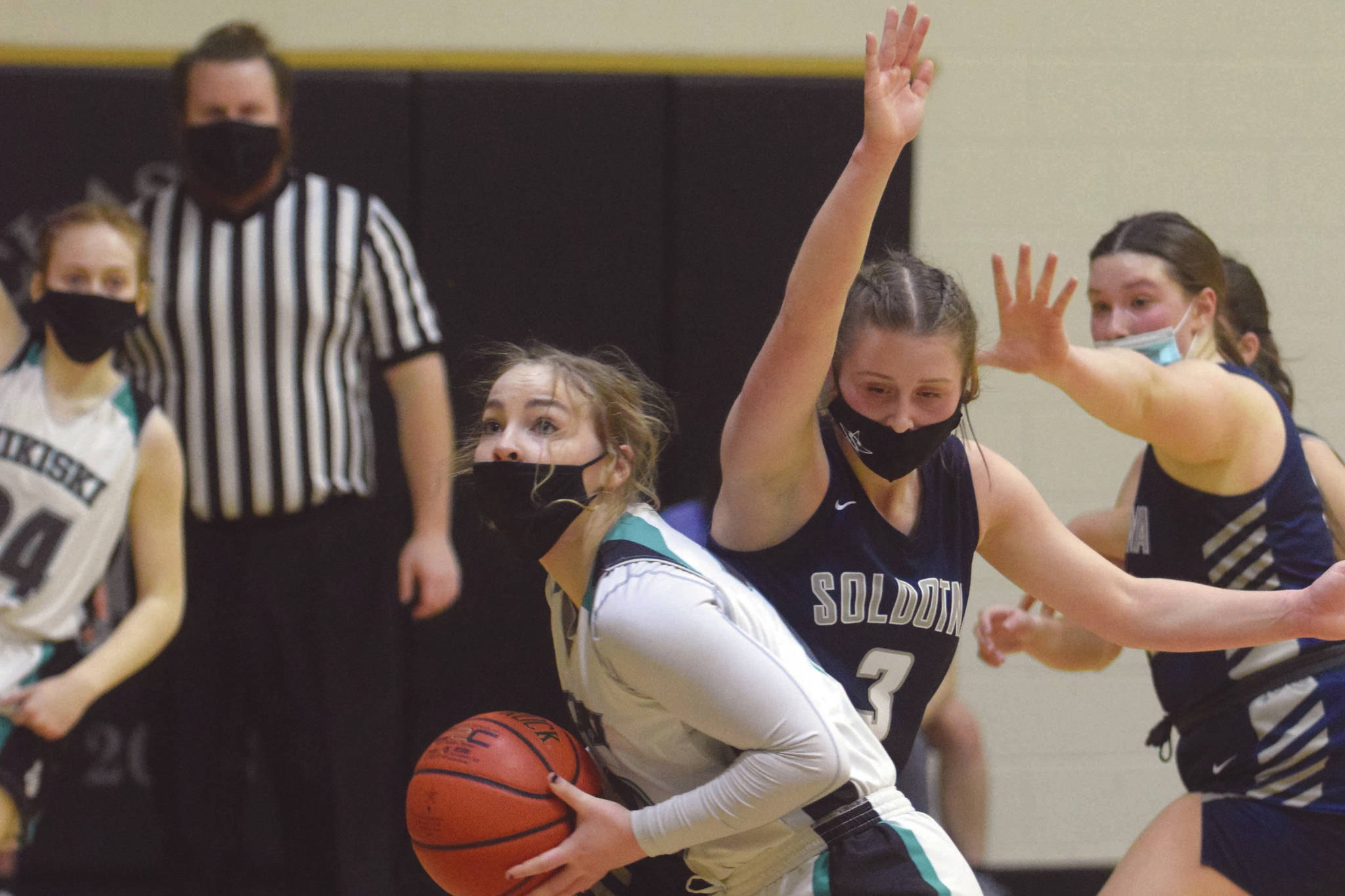 Nikiski’s Lillian Carstens drives to the basket while Soldotna’s Rhys Cannava defends Saturday, Jan. 30, 2021, at Nikiski High School in Nikiski, Alaska. (Photo by Jeff Helminiak/Peninsula Clarion)