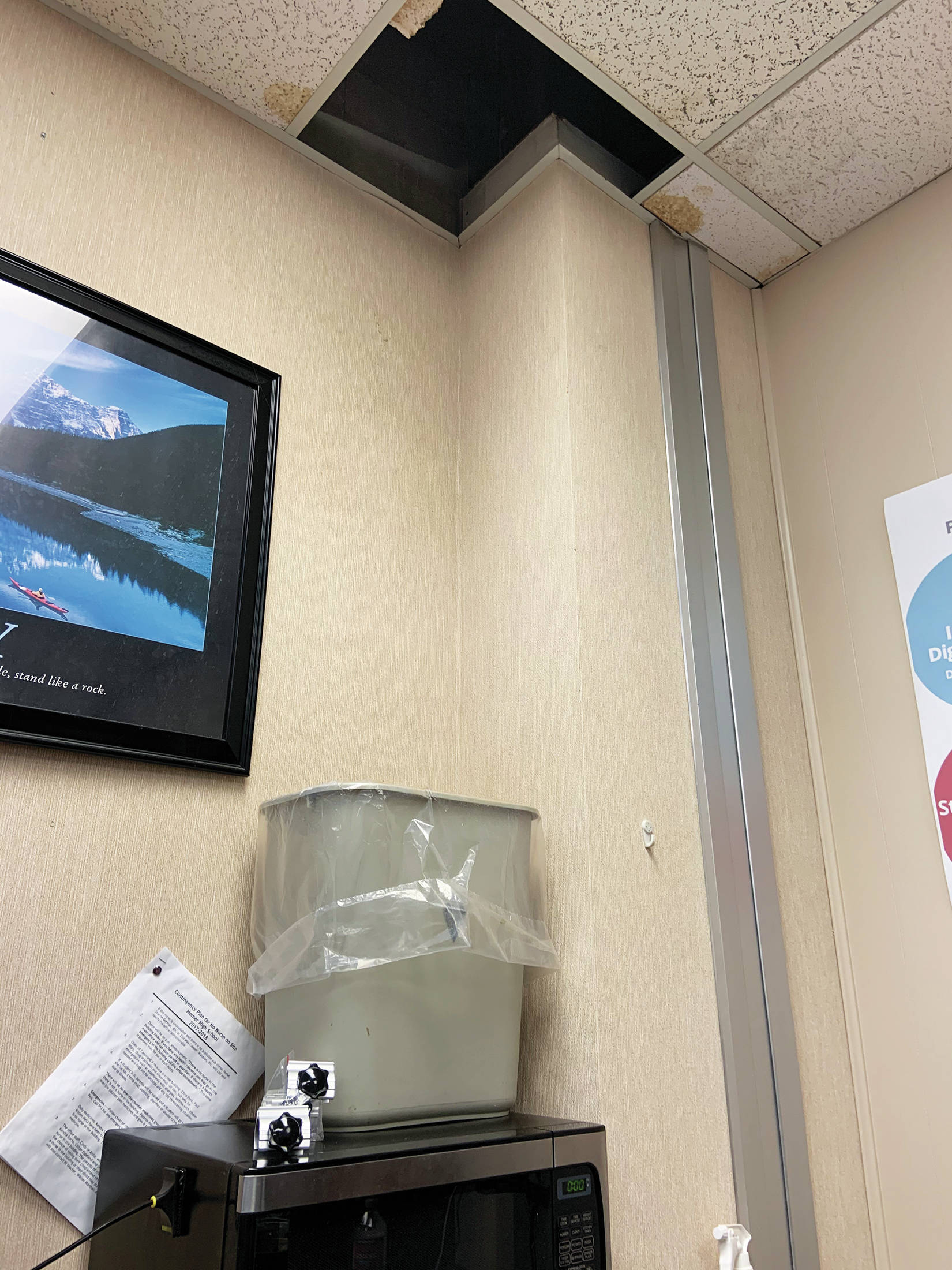 A trash can catches water falling through the hole left by a broken ceiling tile in an office at Homer High School in Homer, Alaska. (Photo courtesy Doug Waclawski)