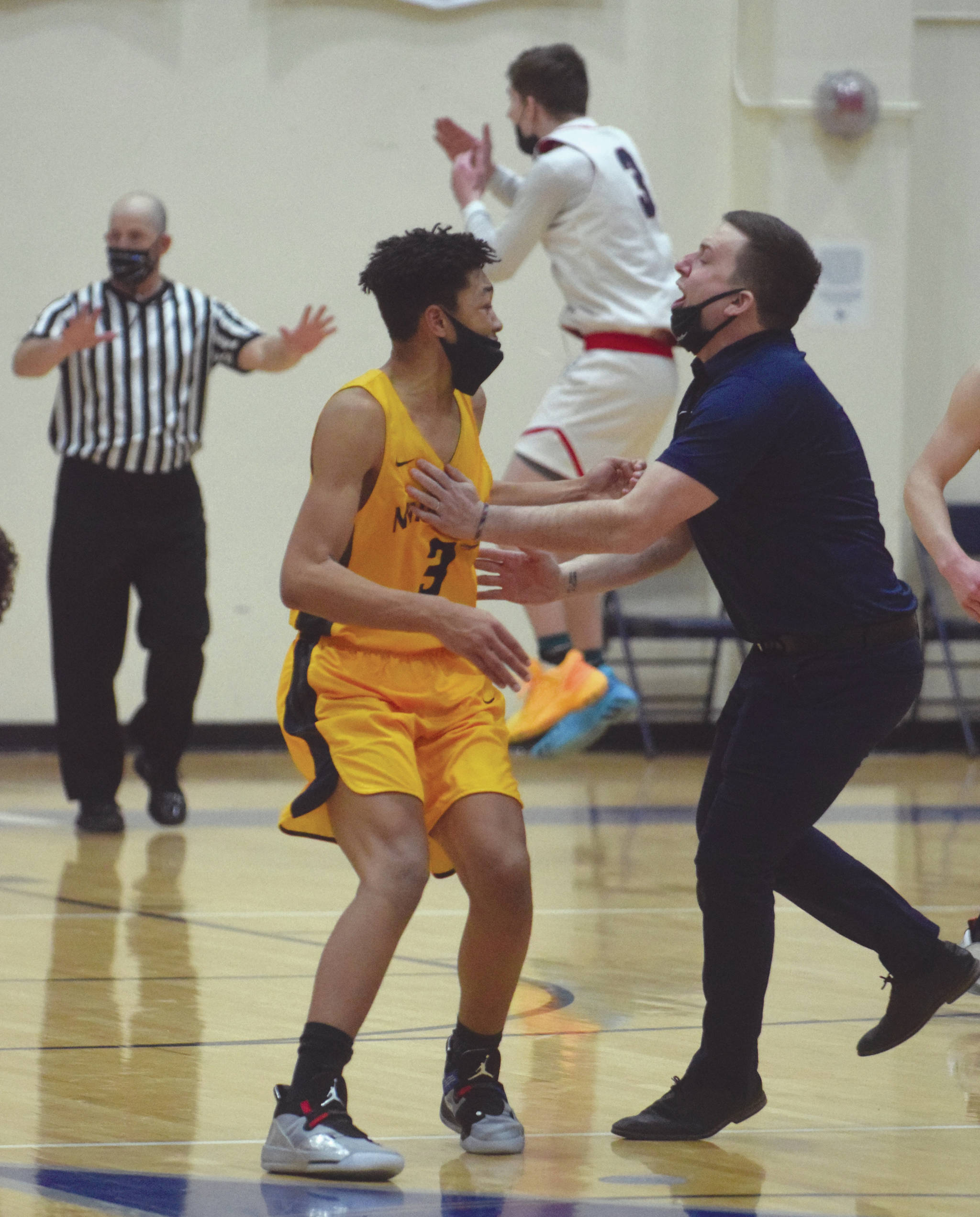 Ninilchik assistant coach Nick Finley congratulates Jaylin Scott after Scott’s basket put the Wolverines up 71-69 in the Peninsula Conference championship game Friday, March 19, 2021, at Soldotna High School in Soldotna, Alaska. The final buzzer sounded after Scott’s basket, but Lumen’s Daniel Bennett, background, got his timeout and .5 seconds back on the clock, setting up Lumen’s win. (Photo by Jeff Helminiak/Peninsula Clarion)