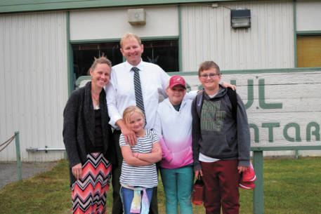 Eric Pederson, principal of Paul Banks Elementary School, stands with his family outside the school in this undated photo in Homer, Alaska. (Photo courtesy Eric Pederson)