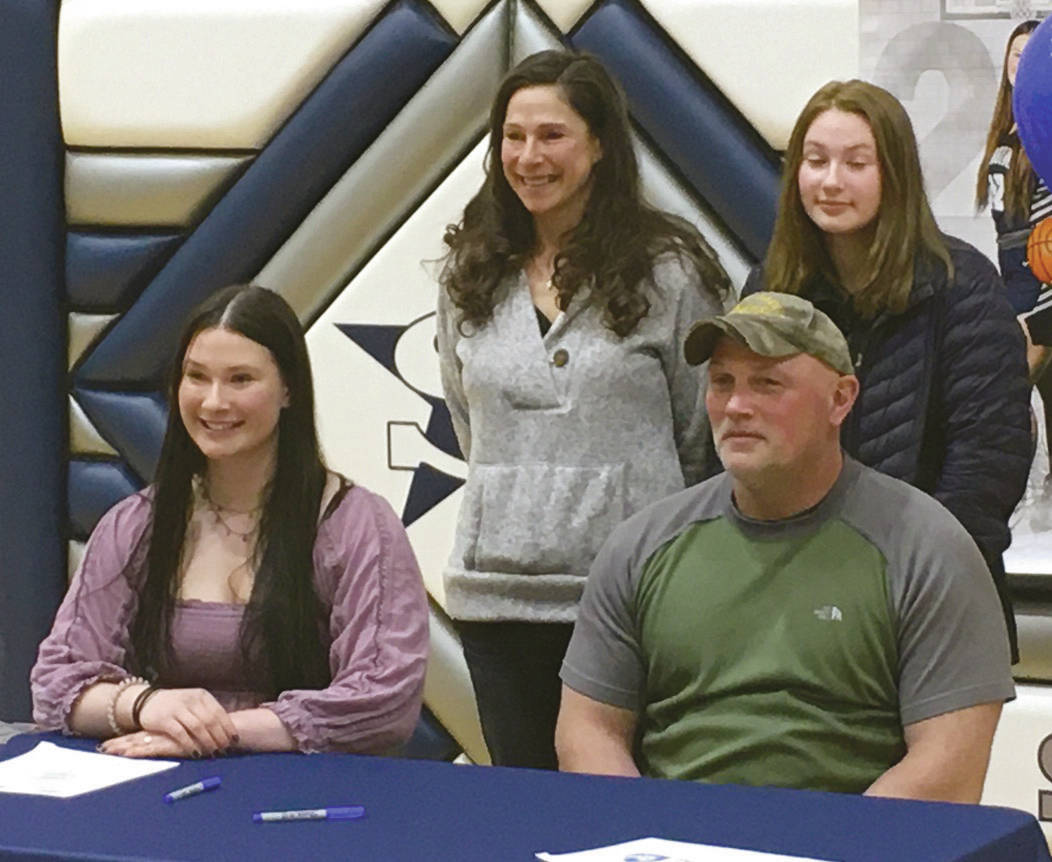 Soldotna senior Autumn Fischer signs her National Letter of Intent on Friday, March 26, 2021, at Soldotna High School in Soldotna, Alaska. Next to Autumn is her father, Eric Fischer. In the back row is mother, Judith Fischer, and sister, Brook Fischer. (Photo provided)