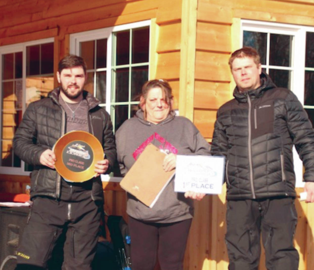 Soldotna’s Travis Temple and Chad Moore accept awards from Cindi Herman of Skwentna Roadhouse after the 5th Annual Skwentna XC Snowmachine Race on Saturday, March 27, 2021. (Photo provided)