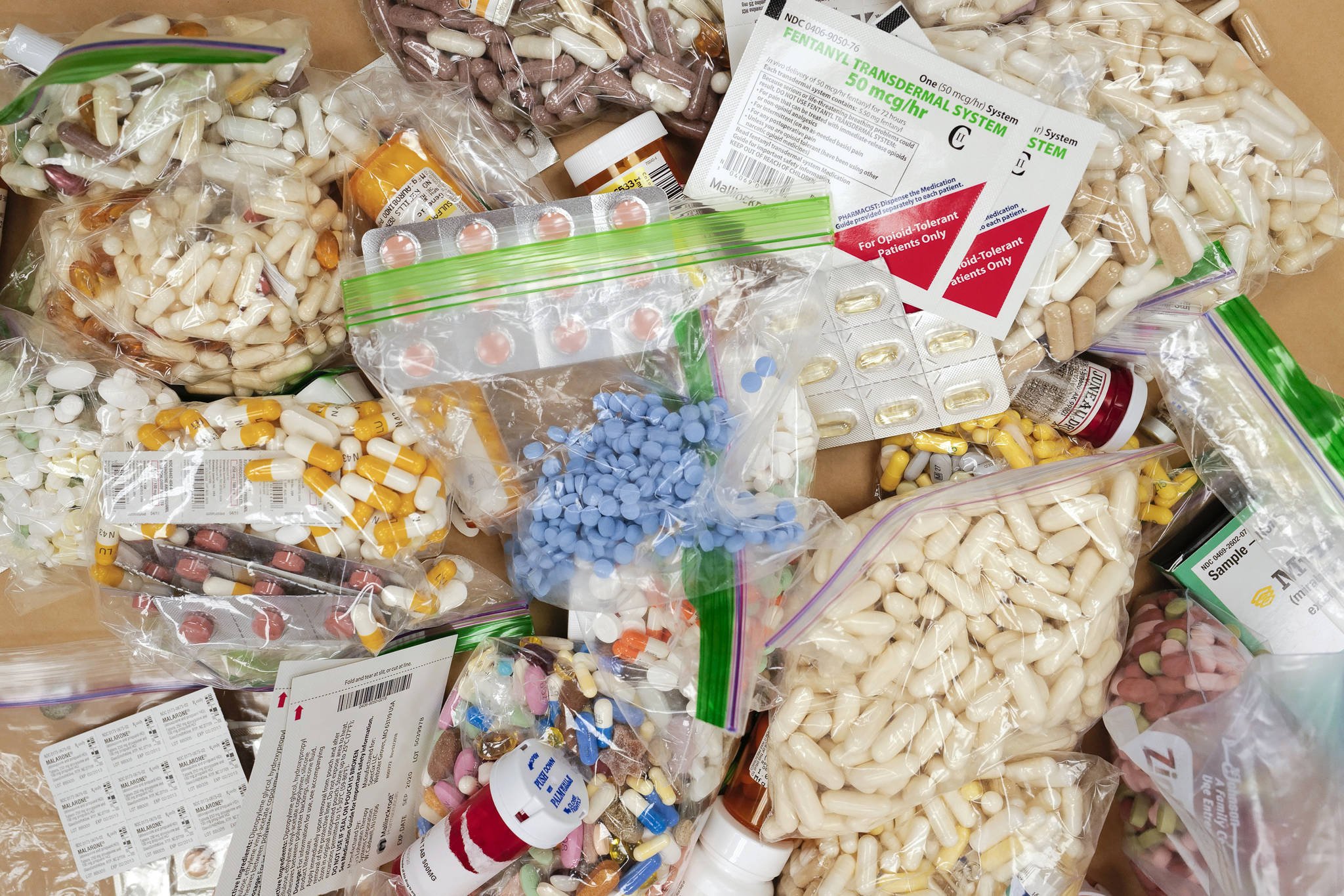 Prescriptions drugs, vitamins, hormones, and other drugs left in the drug drop box in the lobby of the Juneau Police Department displayed on Thursday, Sept. 26, 2019. The state is suing prescription drug companies, accusing them of helping to fuel a drug crisis in the state. (Michael Penn / Juneau Empire File)