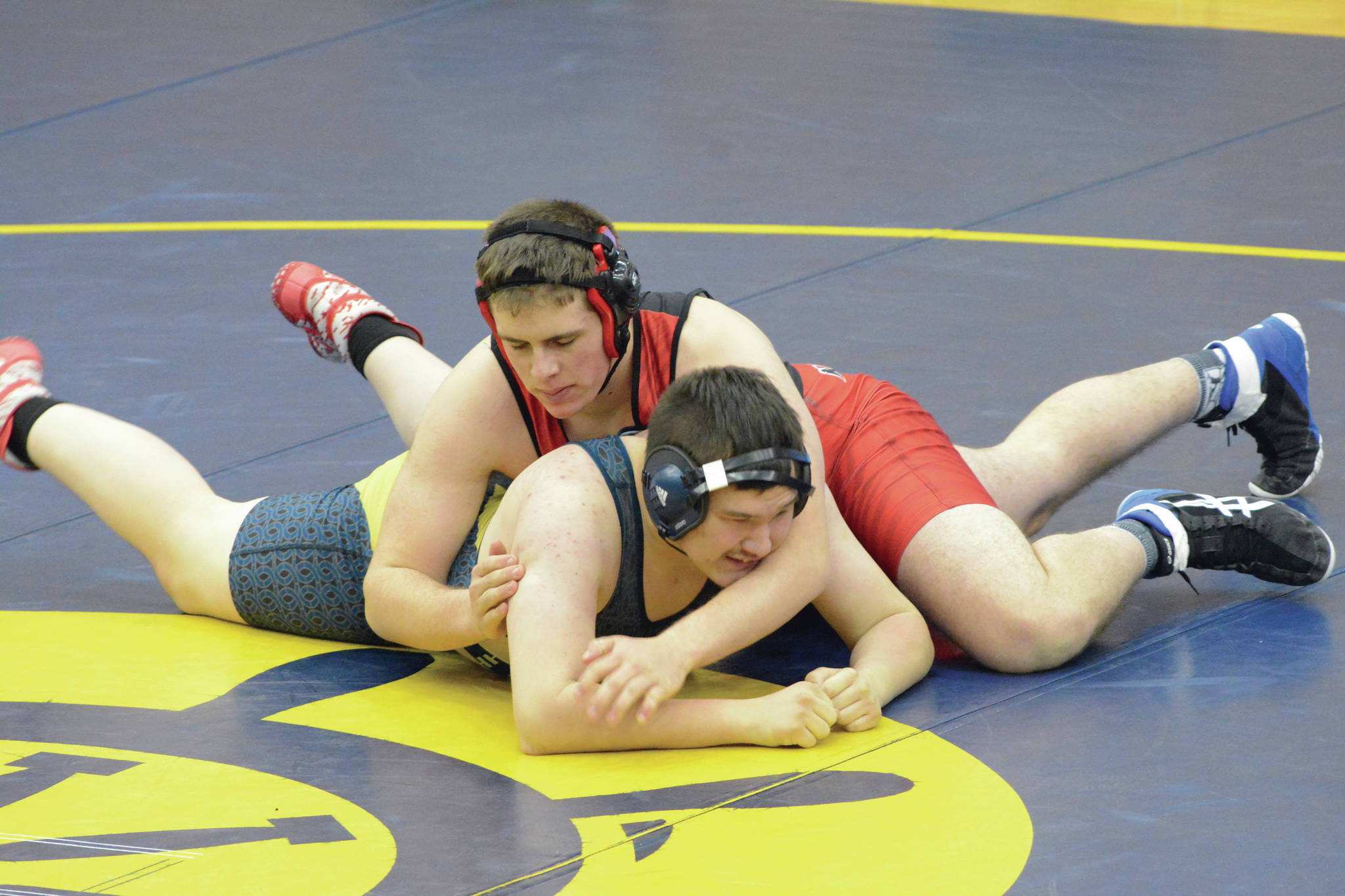 Kardinal Morgan Starks, tops, wrestles Mariner Bruce Graham, bottom, in a meet on Tuesday, April 6, 2021, in the Alice Witte Gym at Homer High School in Homer, Alaska. (Photo by Michael Armstrong/Homer News)