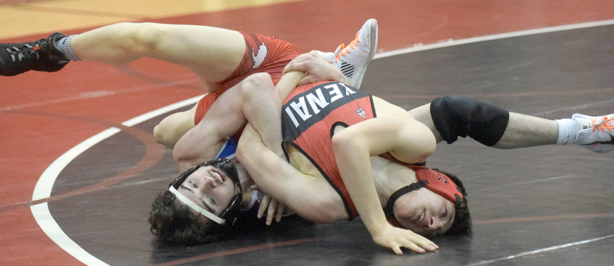 Caleb O’Hara works to a major decision of Kenai Central’s Talon Whicker at 125 pounds Tuesday, April 13, 2021, at Kenai Central High School in Kenai, Alaska. (Photo by Jeff Helminiak/Peninsula Clarion)