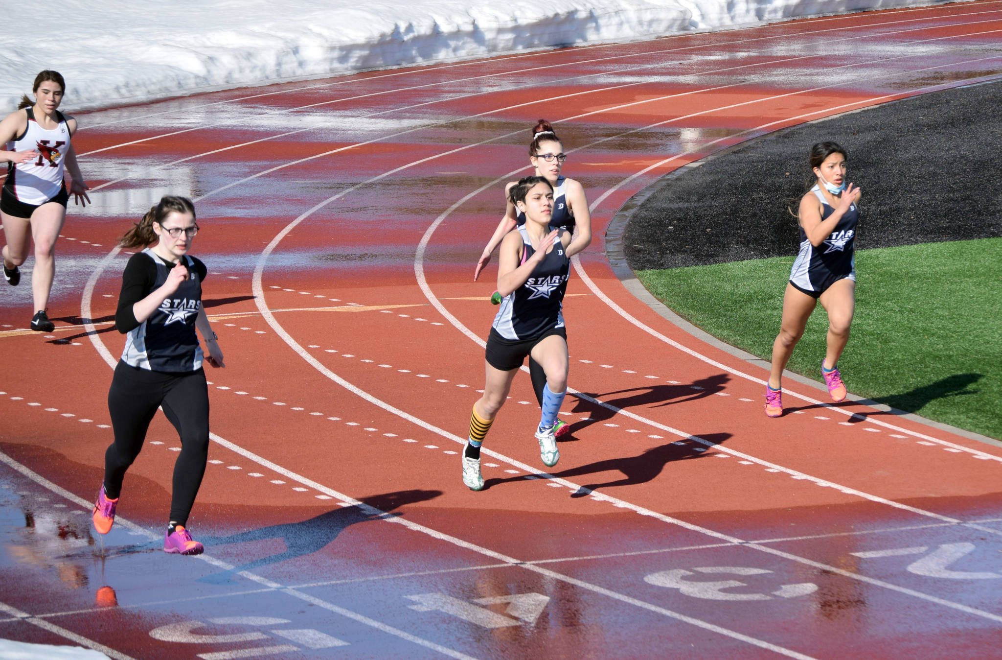 A heat of five runners competes in the 200-meter dash Friday in a dual meet between Kenai Central and Soldotna. Heats were limited to five runners due to the snow surrounding the track at Kenai Central High School in Kenai, Alaska. (Photo by Jeff Helminiak/Peninsula Clarion)