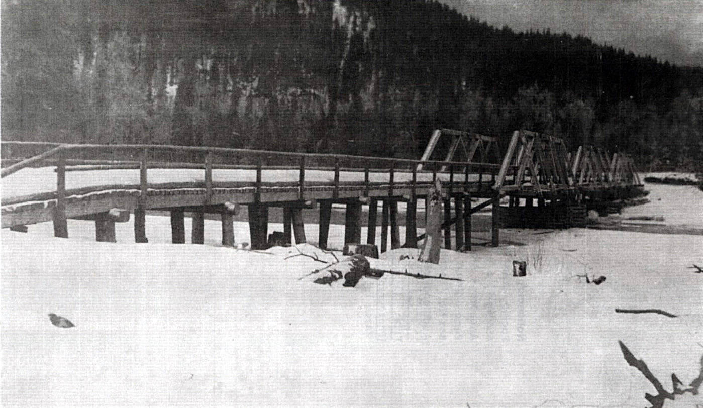 This 1923 Alaska Road Commission photo shows the original bridge over Schooner Bend on the Kenai River, before it took on its more familiar appearance as a covered bridge. The wooden bridge, erected in 1920, was dismantled in the 1950s after a steel span located downstream replaced it.