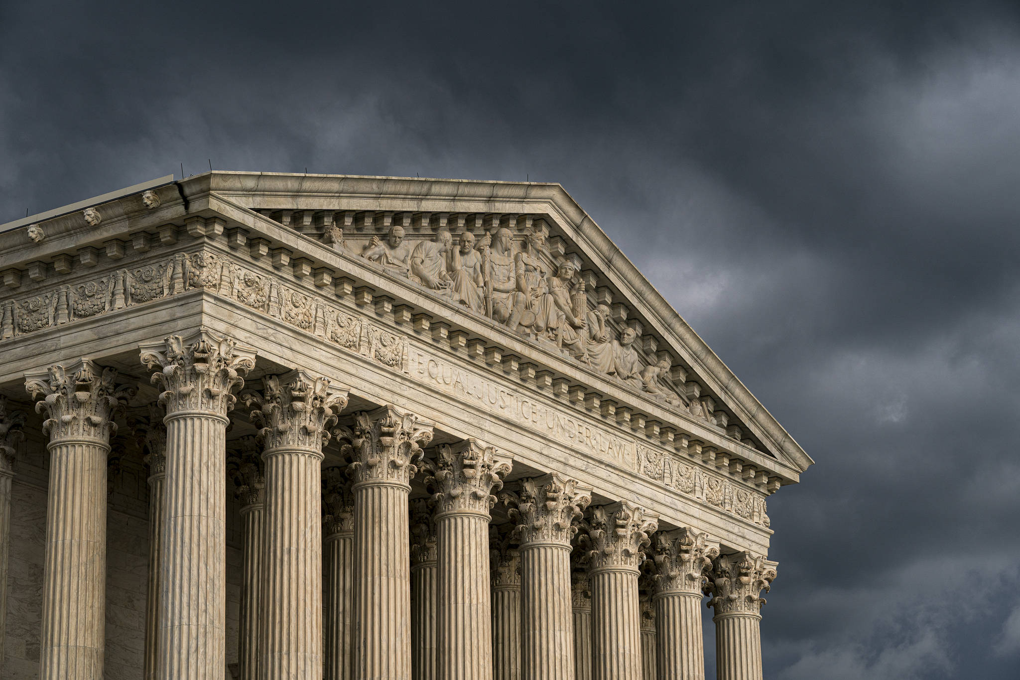 In this June 20, 2019, file photo, the Supreme Court is seen in Washington as a storm rolls in. The Supreme Court seems inclined to say that hundreds of millions of dollars in coronavirus relief money tied up by a court case should benefit Alaska Natives, rather than be spread more broadly among Native American tribes.The justices were hearing arguments April 19, 2021, in a case involving the massive pandemic relief package passed last year and signed into law by then-President Donald Trump. (AP Photo/J. Scott Applewhite, File)
