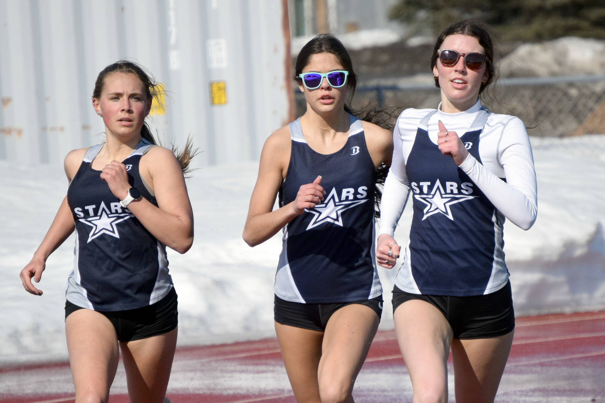 Soldotna’s Jordan Strausbaugh, Erika Arthur and Ellie Burns prepare for the stretch run in the 800-meter run at Kenai Central High School in Kenai, Alaska, on Friday, April 16, 2021. (Photo by Jeff Helminiak/Peninsula Clarion)