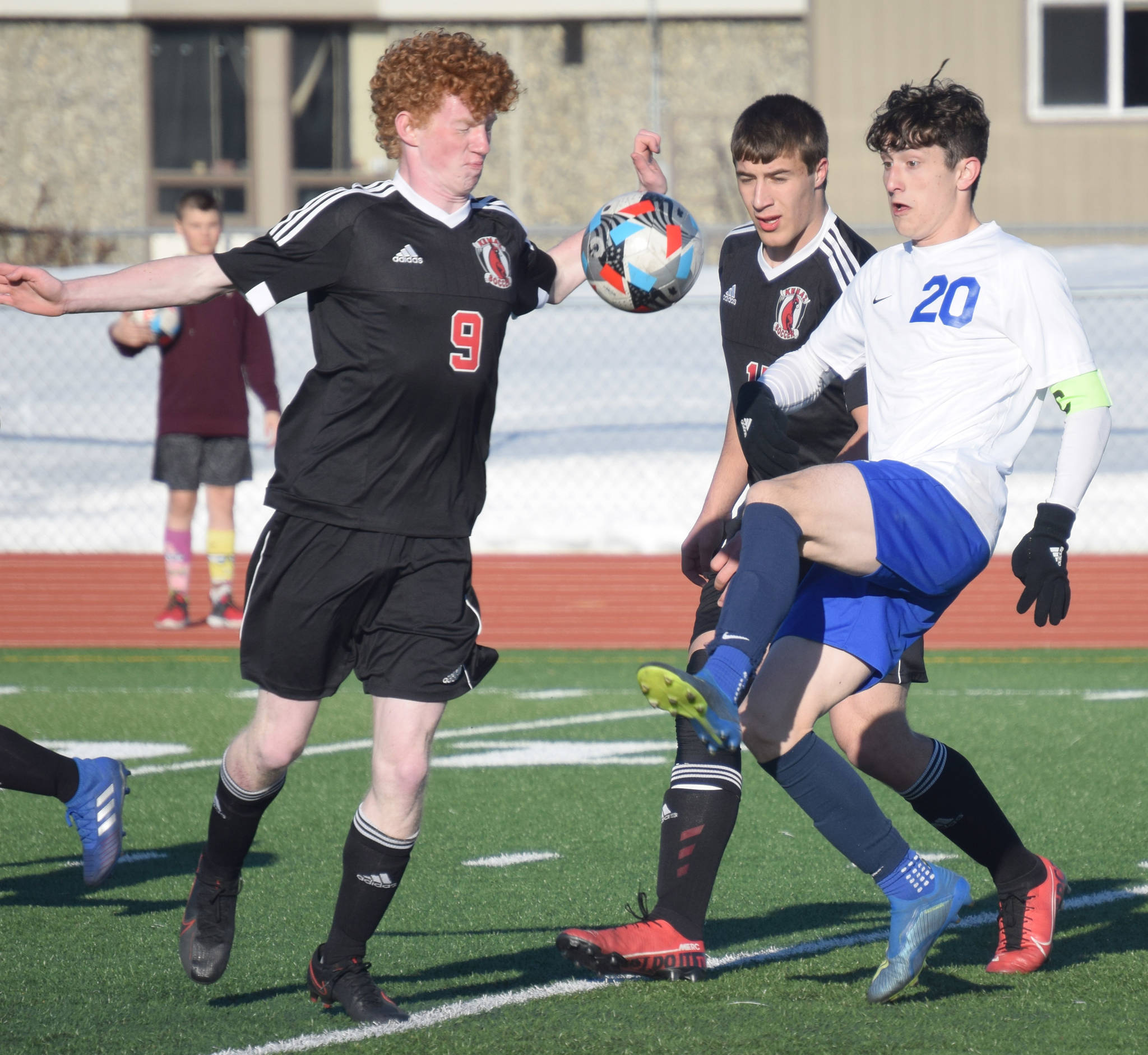 Kenai Central’s Joe Hamilton and Tucker Vann take on Soldotna’s Josh Heiber on Tuesday, April 20, 2021, at Kenai Central High School in Kenai, Alaska. (Photo by Jeff Helminiak/Peninsula Clarion)